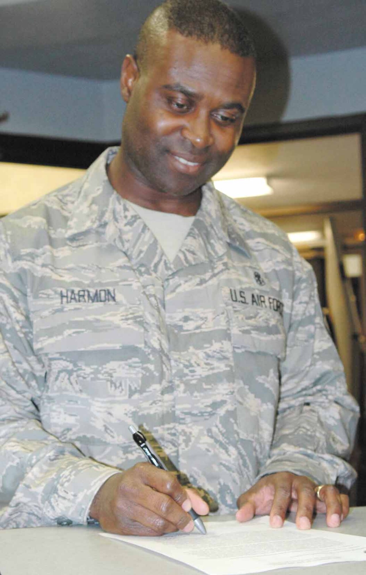 Chief Master Sgt. Eric A. Harmon, 72nd Air Base Wing command chief, signs a housing information release form following Tuesday’s Housing Privatization town hall meeting.  Completing the release form is one of the actions housing residents need to accomplish right away.  (Air Force photo by Ron Mullan)