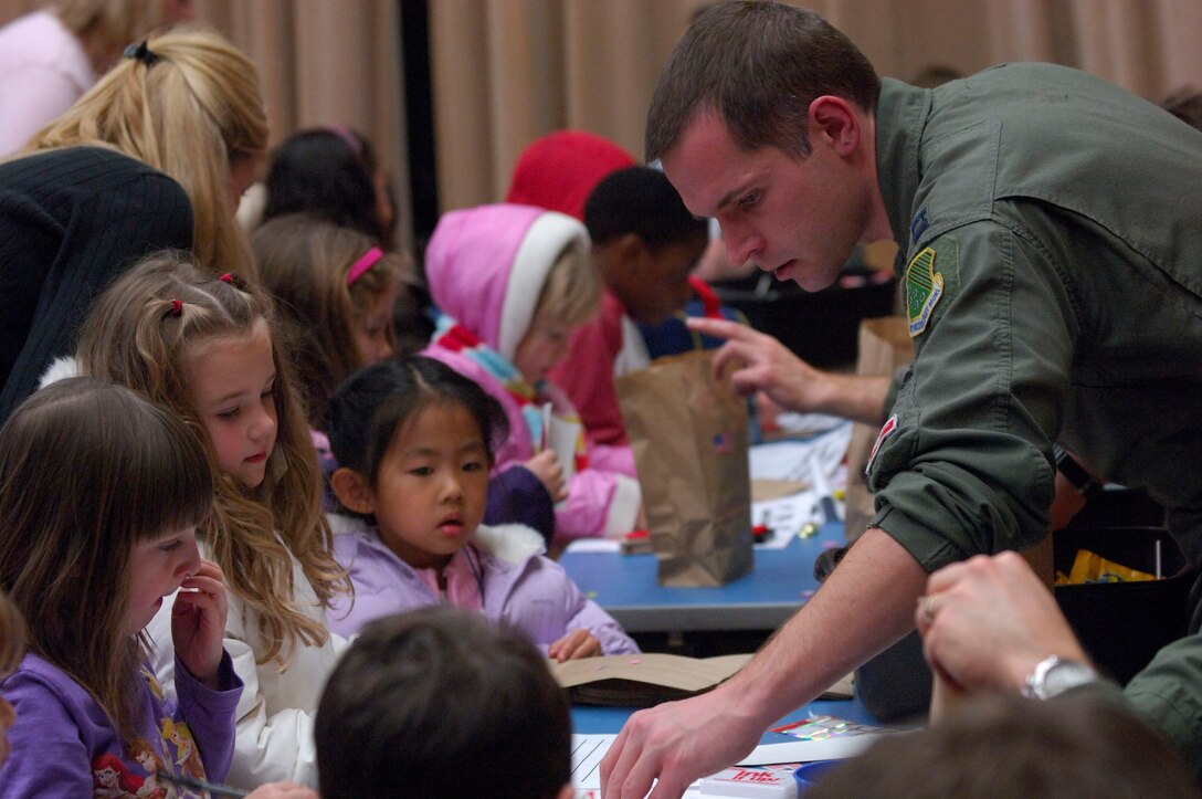 LANGLEY AIR FORCE BASE, Va. -- Capt Michael Palik, an F-15 Eagle pilot with the 71st Fighter Squadron, helps a group of Conventry Elementary School students in Yorktown, Va., decorate care bags Jan. 14 for soldiers in Iraq. The 71st FS, and other military units on the peninsula have partnered with the school’s PTA and the United Service Organization to assist in implementing a program that helps children send messages of encouragement to soldiers in Iraq. (U.S. Air Force photo/Staff Sgt. Samuel Rogers)