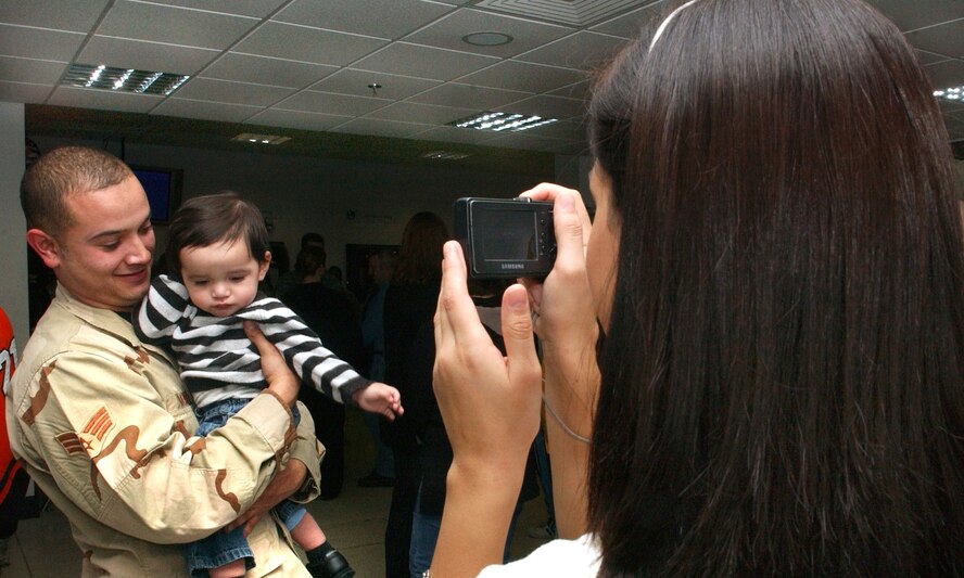 Victoria Martinez waits for the perfect opportunity to snap a long awaited photo of her husband, Senior Airman Christopher Martinez, 100th Logistics Readiness Squadron, and their son, Christopher Jan. 11, at the RAF Mildenhall passenger terminal.  Airman Martinez just returned from a 6-month deployment to Southwest Asia.  (U.S. Air Force photo by Staff Sgt. Tyrona Pearsall)