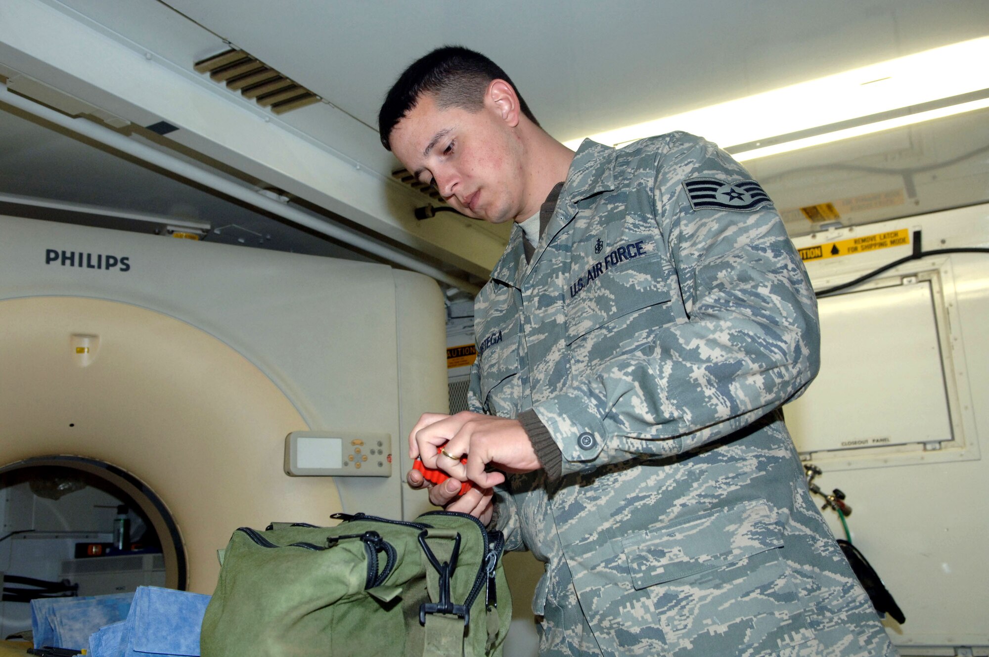 Staff Sgt. Orlando Ortega selects tools before performing maintenance on a CT scanner at the Air Force Theater Hospital Jan. 12 at Balad Air Base, Iraq. The scanner provides doctors a three-dimensional internal image of a patient taken from a series of angles. Sergeant Ortega is a 332nd Expeditionary Medical Support Squadron biomedical equipment technician and deployed from Barksdale Air Force Base, La. (U.S. Air Force photo/Senior Airman Terri Barriere) 
