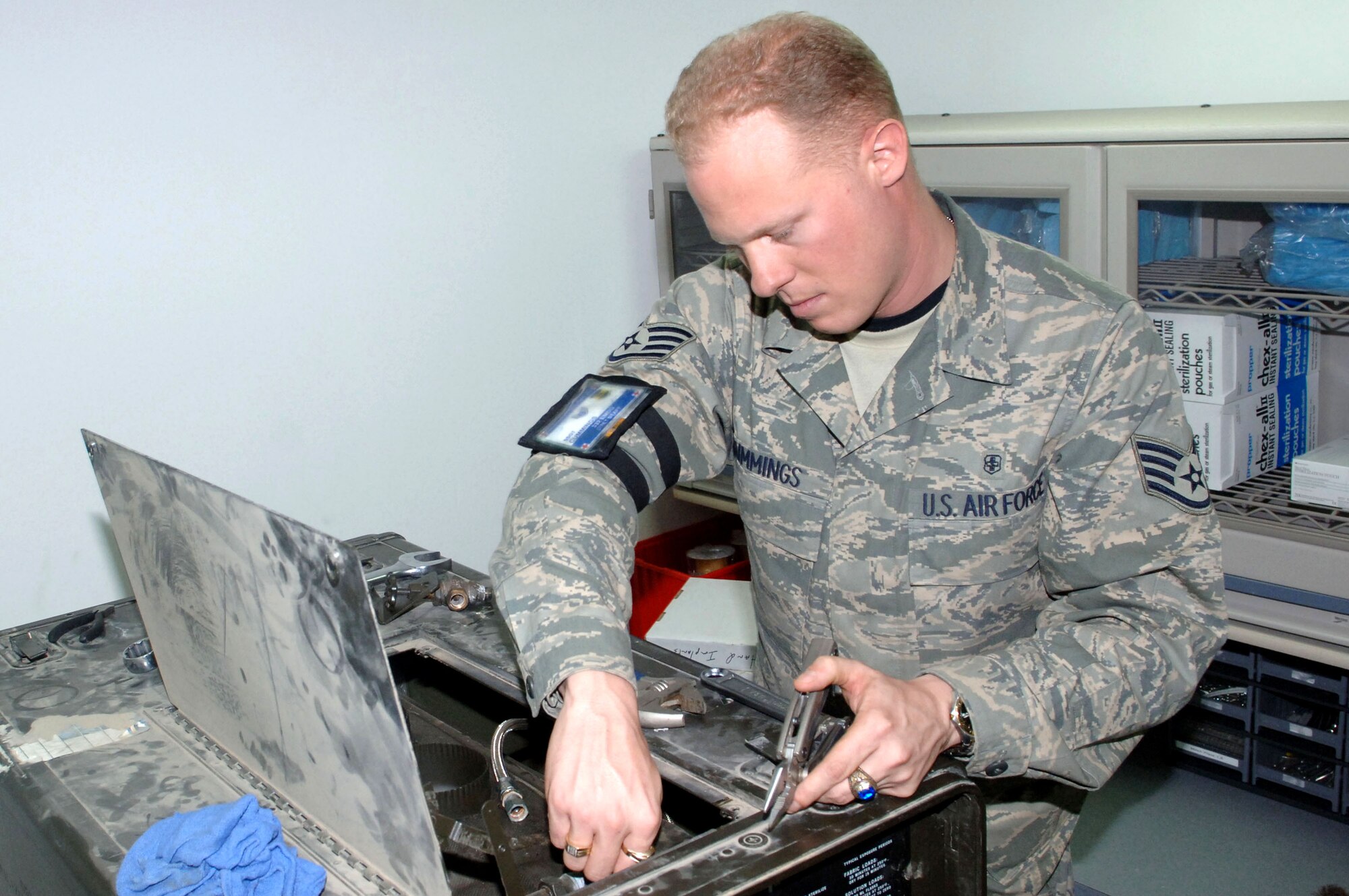 Staff Sgt. Brian Cummings removes a screw from the inside of a sterilizer machine here during routine maintenance Jan. 12 at Balad Air Base, Iraq. The machine is used to sterilize surgical equipment at the Air Force Theater Hospital. Sergeant Cummings is a 332nd Expeditionary Medical Support Squadron biomedical equipment technician and deployed from Langley Air Force Base, Va. (U.S. Air Force photo/Senior Airman Terri Barriere) 

