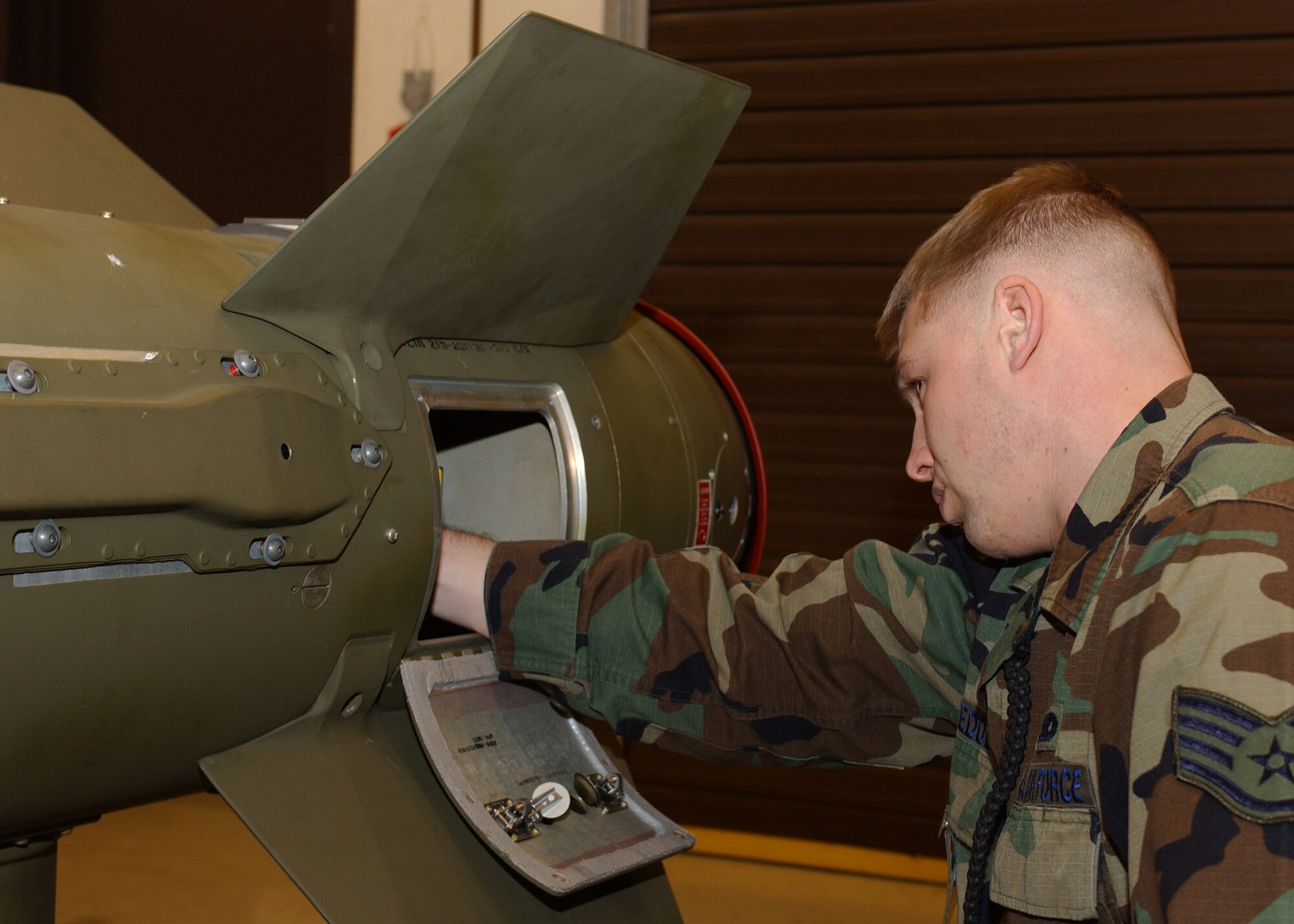 Staff Sgt. Ryan Goedde, 48th Munitions Squadron munitions systems specialist, installs the fuse, which is the starting charge for an explosive train, on an air-to-ground     munition (AGM-130) at RAF Lakenheath, England Jan. 9. The fuse is routinely replaced as necessary for weapon functionality and accuracy. (U.S. Air Force photo by Airman 1st Class Torri Ingalsbe)