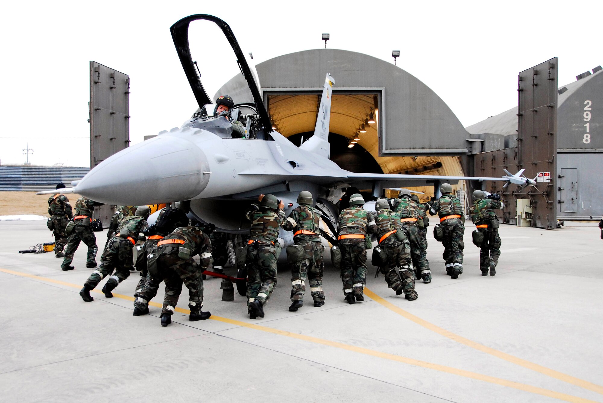 Airmen from the 79th Fighter Squadron push an F-16 Fighting Falcon into a hangar Jan. 15 at Kunsan Air Base, South Korea. More than 300 Airmen and several aircraft from the 79th Fighter Squadron from Shaw Air Force Base, S.C., are in South Korea as the squadron's air and space expeditionary force deployment to help maintain peace and stability in the Pacific region. (U.S. Air Force photo/Senior Airman Steven R. Doty)

