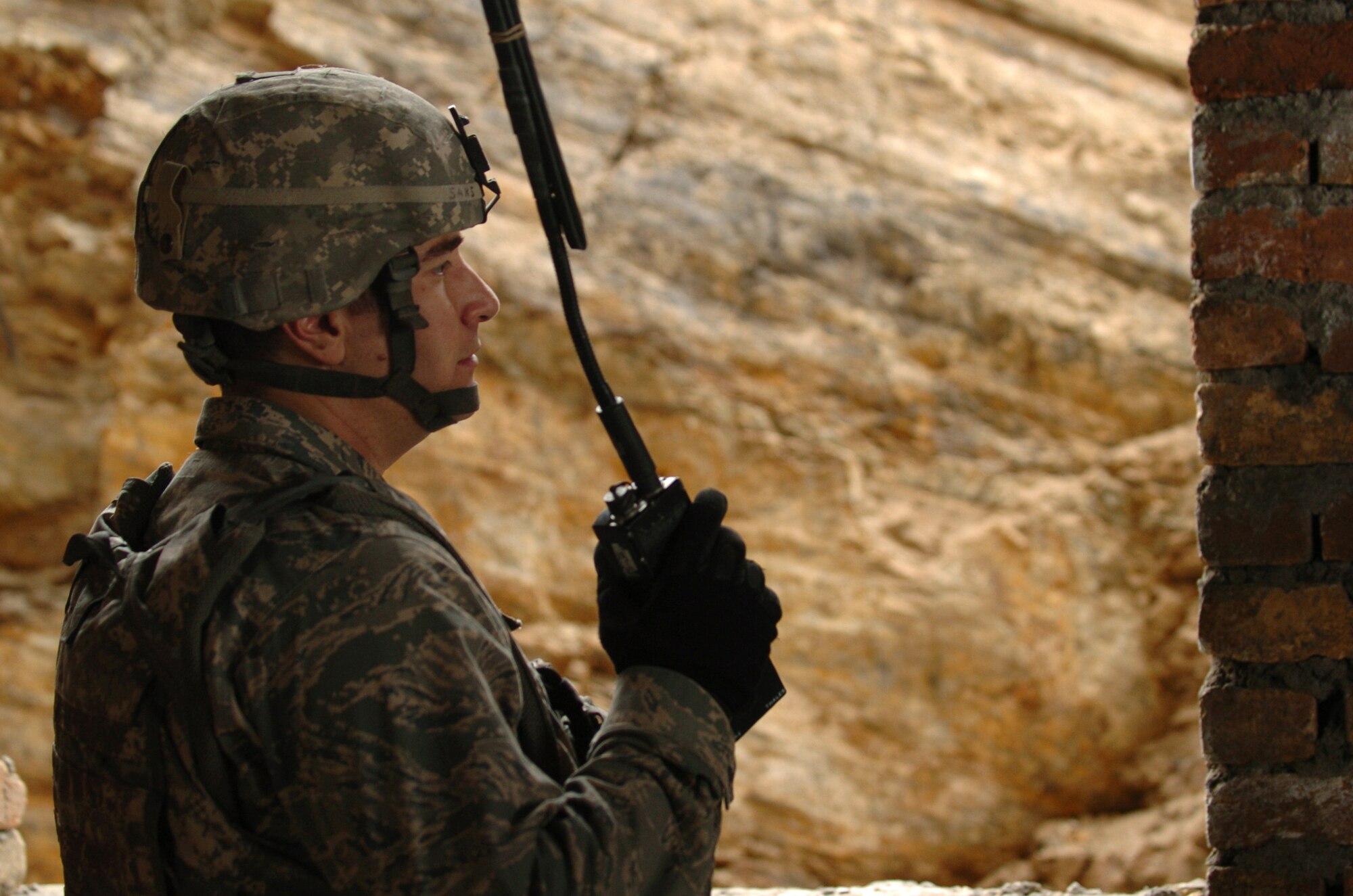 BAGRAM AIRFIELD, Afghanistan – Air Force Capt. Erick Saks, International Security Assistance Force Bagram Provincial Reconstruction Kapisa Province Team Information Operations officer, speaks to the PRT's security members over a hand-held radio Jan. 10. Captain Saks was part of a team performing a quality assurance inspection on the Kohband District Center in Kohband District, Kapisa Province. Captain Saks is 10 months into a one-year deployment from McGuire Air Force Base, N.J., to Afghanistan. The PRT works with provincial and district governments, as well as village leaders to develop Kapisa Province. (U.S. Air Force photo/Senior Airman James Bolinger)