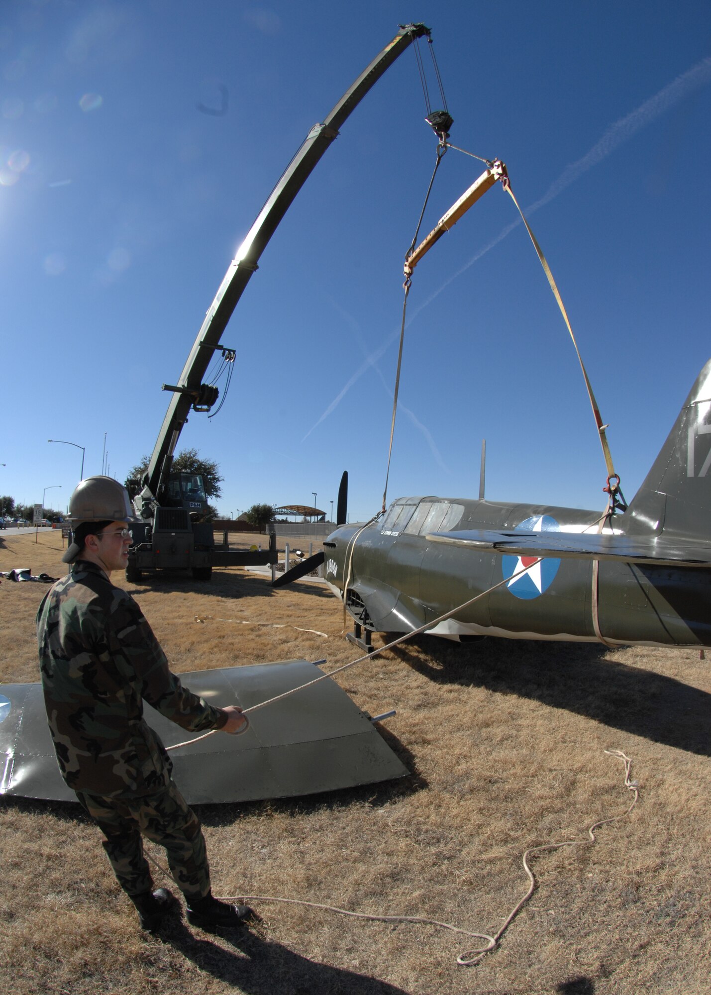 Airman Richard Dunn, 7 Logistics Readiness Squadron, assists in placing the P-40 at the front gate back on its mount. The plane was taken off for refurbishment.
The P-40 is the plane that Lt. Col. "Ed" Dyess, whom the base is named after, flew during World War II. Col. Dyess was a prisoner of war in 1942 and participated in the Bataan Death March.