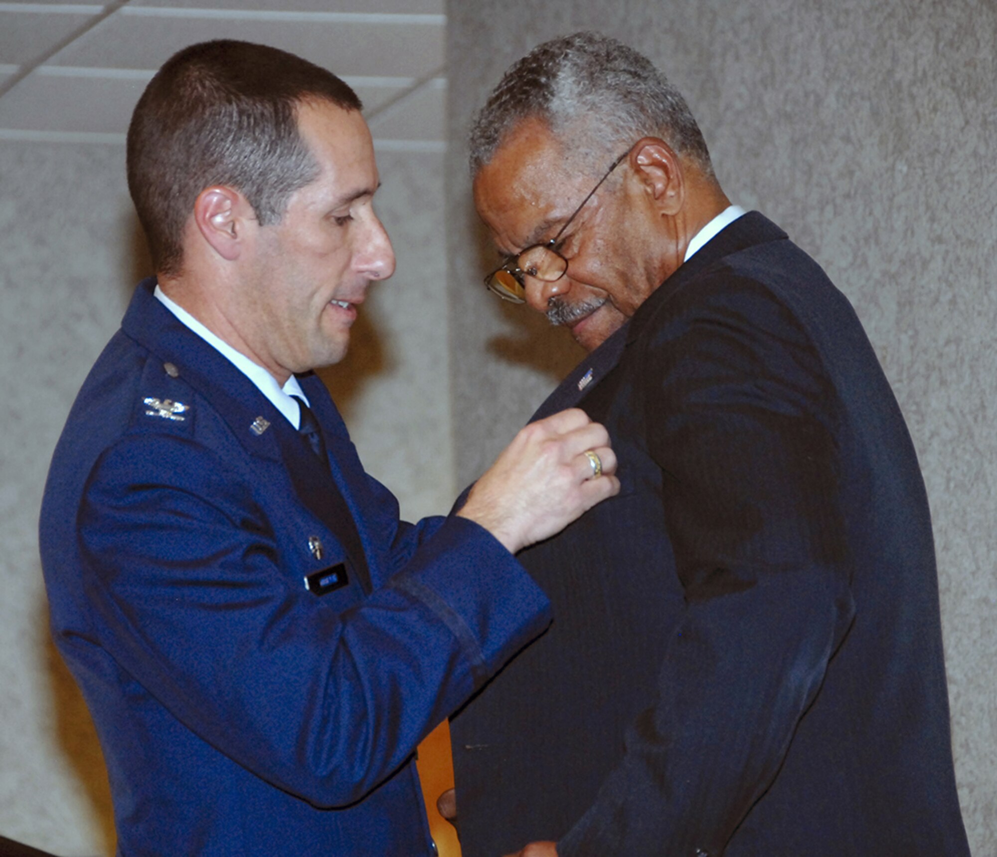 Col. Steven Morani, left, commander of the 82nd Training Group at Sheppard Air Force Base, Texas, pins a master aircraft mechanic and munitions badge on Don Elder, inducting him into the fraternity of master maintainers. The colonel said Mr. Elder, and other Tuskegee Airmen, were pioneers in the integration and diversity of today's Air Force. (U.S. Air Force photo/Sandy Wassenmiller)