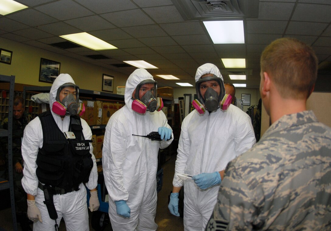 Airman 1st Class Andrew Kim, 36th Civil Engineer Squadron Readiness Flight, Staff Sergeants William Mitchell and Sean Halsty, 36th Medical Group Bionenvironmental Engineering, get a briefing from Tech. Sgt. Curtis McGehee of the 36th Wing Inspector General's Exercise Evaluation Team.  The bioenvironmental team used a Hand-Heald Assay during a Disease Containment Exercise at Andersen to  determine if a substance found in an envelope during the exercise was toxic or not. (U.S. Air Force photo/Airman 1st Class Jonathan Hart)