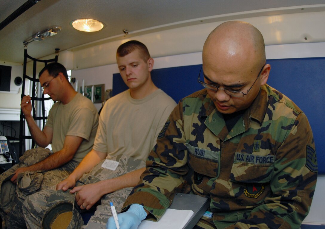 Tech. Sgt. Richard Rubi, 36th Medical Group, takes vital signs of two victims, Staff Sgt. Jeremy Regula and Senior Airman Anthony Powell, both from the 36th Communications Squadron, during the first day of the Disease Containment Exercise at Andersen Jan. 15. (U.S. Air Force photo/Airman 1st Class Jonathan Hart)