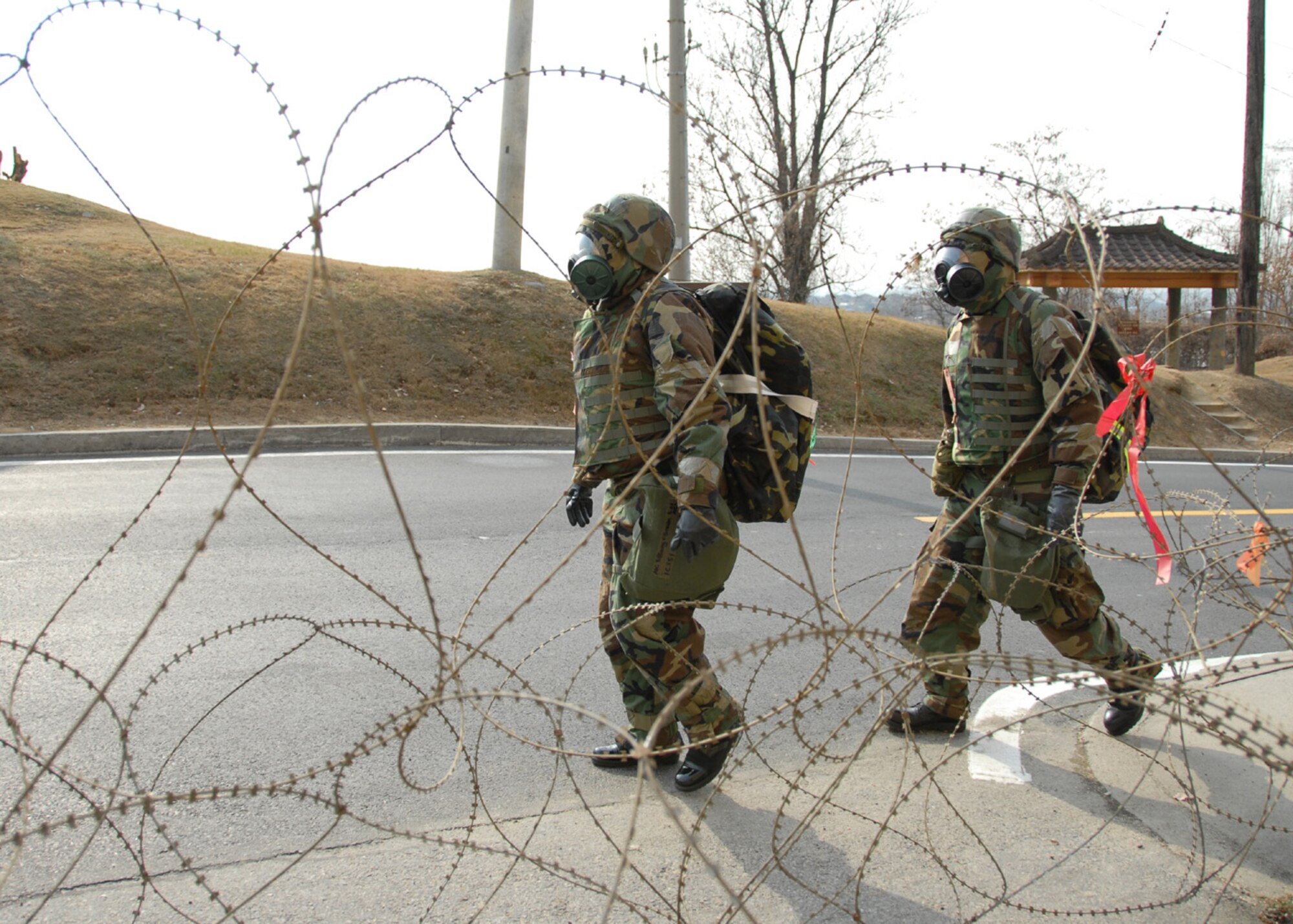 OSAN AIR BASE, Republic of Korea -- Airmen assigned to Osan Air Base walk to work wearing their individual protective equipment during a peninsula-wide exercise at Osan Air Base. The operational readiness exercise tests Team Osan's ability to execute combat operations, receive follow-on forces and defend the base from attack. (U.S. Air Force photo by Senior Master Sergeant Marvin Krause)
