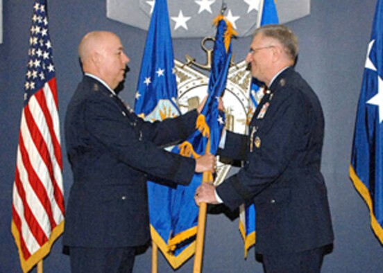Gen. T. Michael Moseley, Air Force chief of staff, passes the United States Air Forces in Europe flag to the new USAFE commander, Gen. Roger Brady, during an assumption-of-command ceremony Jan. 9 at the Pentagon. General Brady was also promoted to four-star general during the ceremony. 