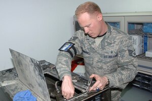 BALAD AIR BASE, Iraq -- Staff Sgt. Brian Cummings, a 332nd Expeditionary Medical Support Squadron biomedical equipment technician, removes a screw from the inside of a sterilizer machine here during routine maintenance. The machine is used to sterilize surgical equipment at the Air Force Theater Hospital, here. Sergeant Cummings is deployed from Langley Air Force Base, Va. (U.S. Air Force photo/Senior Airman Terri Barriere)