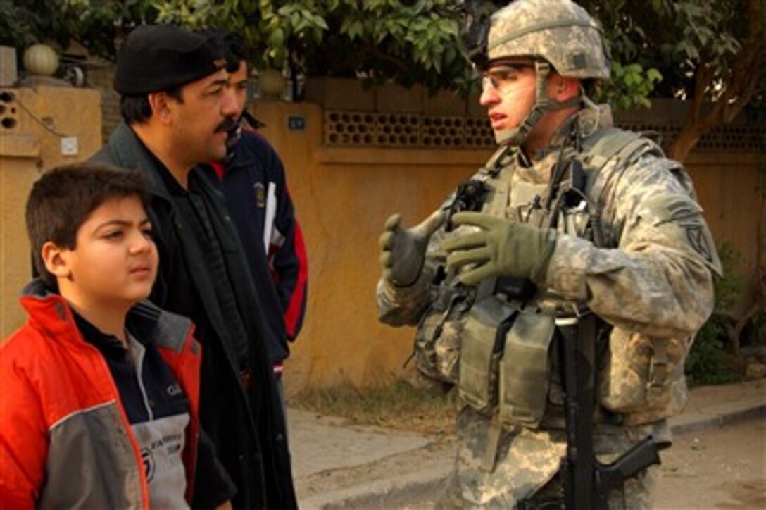 U.S. Army Capt. R.J. Gibson speaks with an Iraqi man during a neighborhood cordon and search mission with Iraqi army soldiers from 1st Battalion, 5th Brigade, 6th Iraqi Army Division in Monsour, Iraq, on Jan. 9, 2008.  Gibson is from Military Transition Team, 2nd Battalion, 4th Infantry Regiment, 2nd Brigade Combat Team.  