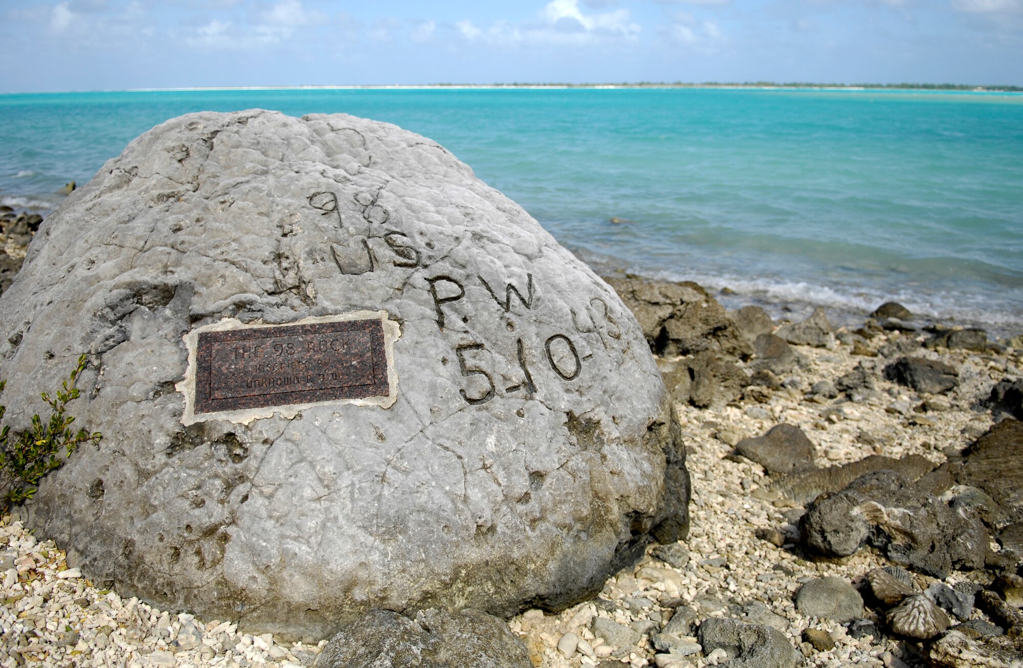 A memorial to prisoners of war is seen on Wake Island Jan. 12, 2008.
The “98 Rock” is a memorial for the 98 U.S. civilian contract POWs who were forced by their Japanese captors to rebuild the airstrip as slave labor, then blind-folded and killed by machine gun on 5 Oct. 1943. An unidentified prisoner escaped, and chiseled “98 US PW 5-10-43” on a large coral rock near their mass grave, on Wilkes Island at the edge of the lagoon. The prisoner was recaptured and beheaded by the Japanese admiral, who was later convicted and executed for these war crimes. (U.S. Air Force photo/TSgt Shane A. Cuomo) 
