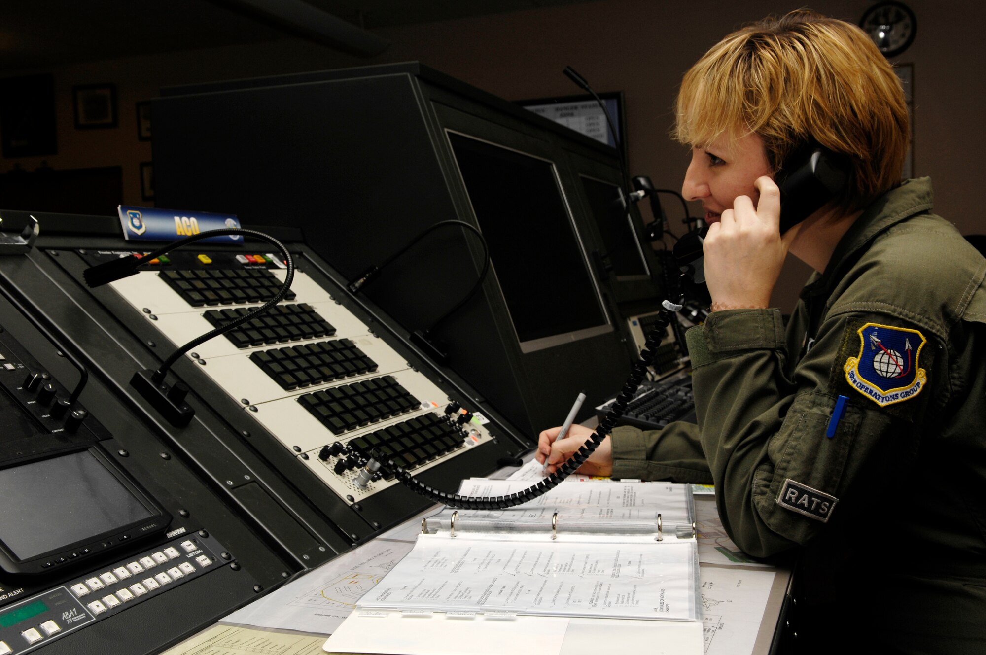 VANDENBERG AIR FORCE BASE, Calif. -- Senior Airman Jillian Voyles, a 2nd Range Operations Squadron aerospace control officer, writes in a range operations manual while speaking on the phone during a training scenario on Jan. 14. Aerospace control officers ensure launch hazard areas are clear of boats, trains, aircraft, and personnel on oil rigs during launch operations. The scenario is the deciding factor on who is selected to be on the elite 30th Space Wing Guardian Challenge Team. Air Force Space Command hails GC as the only space war fighter competition in the Air Force. The competition pits the "best of the best" space war fighters against each other, determining the top space wing teams in the Air Force. The event captures the essence of competition through rigorous evaluation and increases the overall capabilities of operations teams to perform their missions. (U.S. Air Force photo/Airman 1st Class Christian Thomas)
