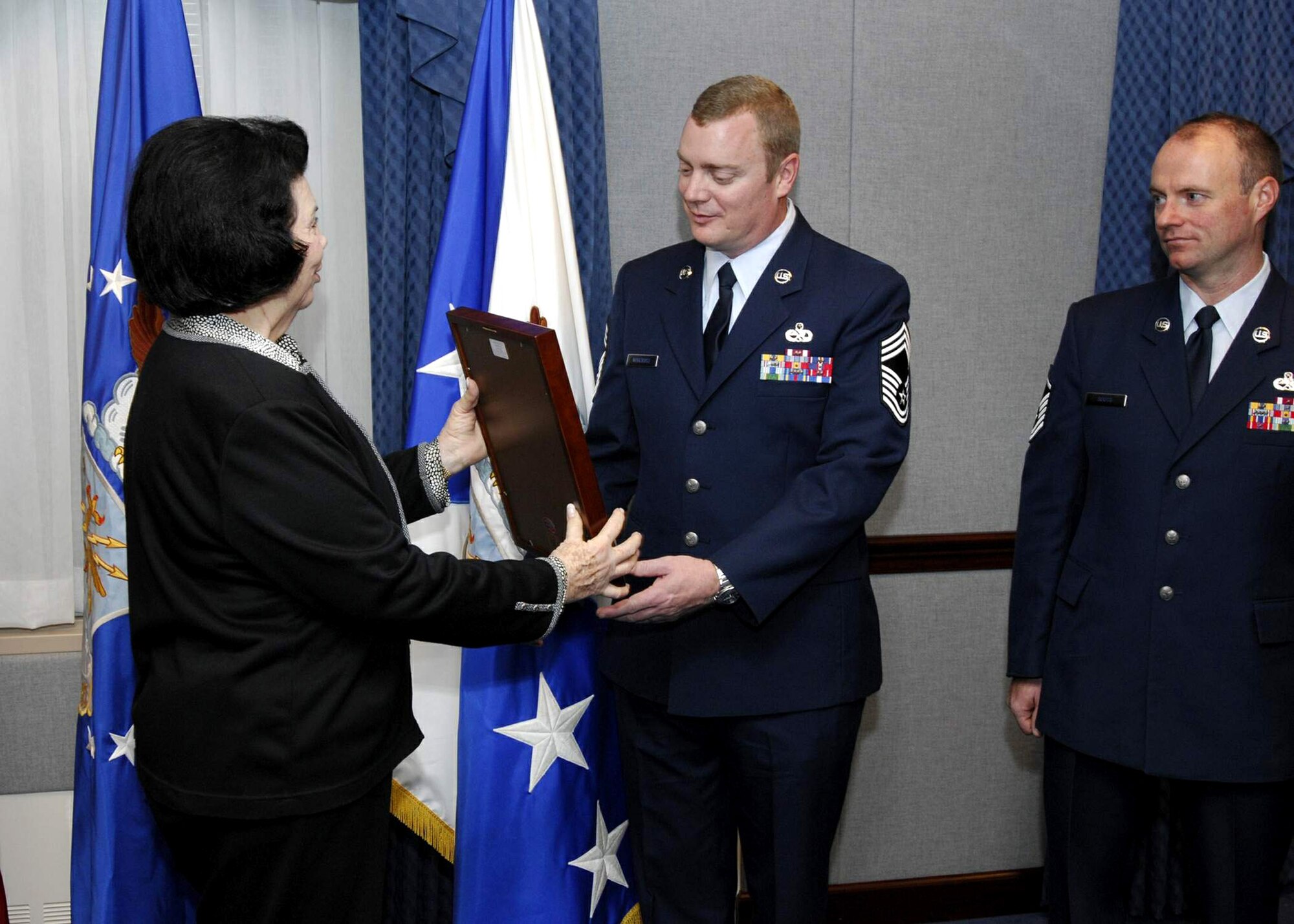 Carol Creech gives the Gen. Wilbur L. Creech Maintenance Excellence Award to Chief Master Sgt. Robert L. Norcross II and Master Sgt. Jeffrey Soots during a ceremony Jan. 16 at the Pentagon. Chief Norcross and Sergeant Soots accepted the award on behalf of the 10,000-plus maintainers and logisticians in Pacific Air Forces command. Mrs. Creech is the wife of the general, who passed away in 2003. (U.S. Air Force photo/Michael Pausic) 