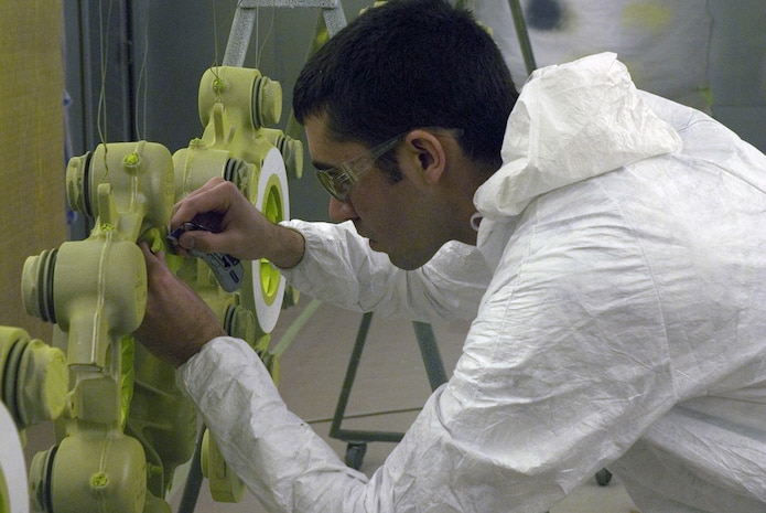 Airman 1st Class Rhett Young, 437th Maintenance Squadron, places green Gerber masking tape on C-17 brake housing prior to their being painted at the aircraft structural maintenance shop Jan. 15. (U.S. Air Force photo/Tech. Sgt. Paul Kilgallon)