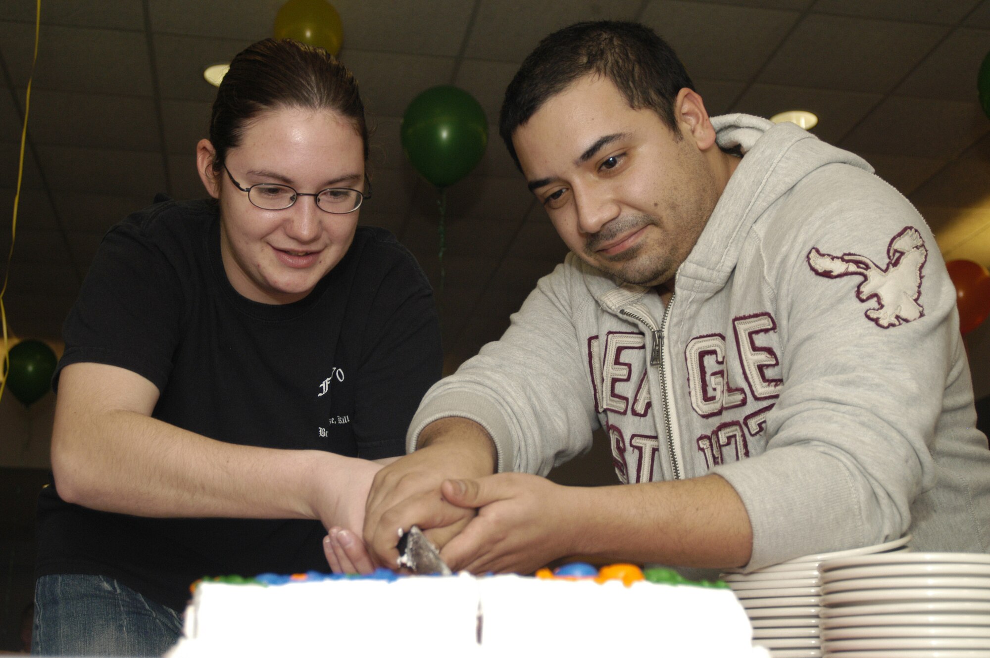 Airman 1st Class Tiffany Stroer and Edgar Sandoval, 436th Maintenance Squadron, cut the birthday cake at the Airmen’s Birthday Dinner at the Patterson Dining Facility Jan. 9. Tradition for ‘cutting of the cake’ is to get the youngest and oldest Airmen to cut the cake together. (U.S. Air Force photo/ Airman Shen-Chia Chu)