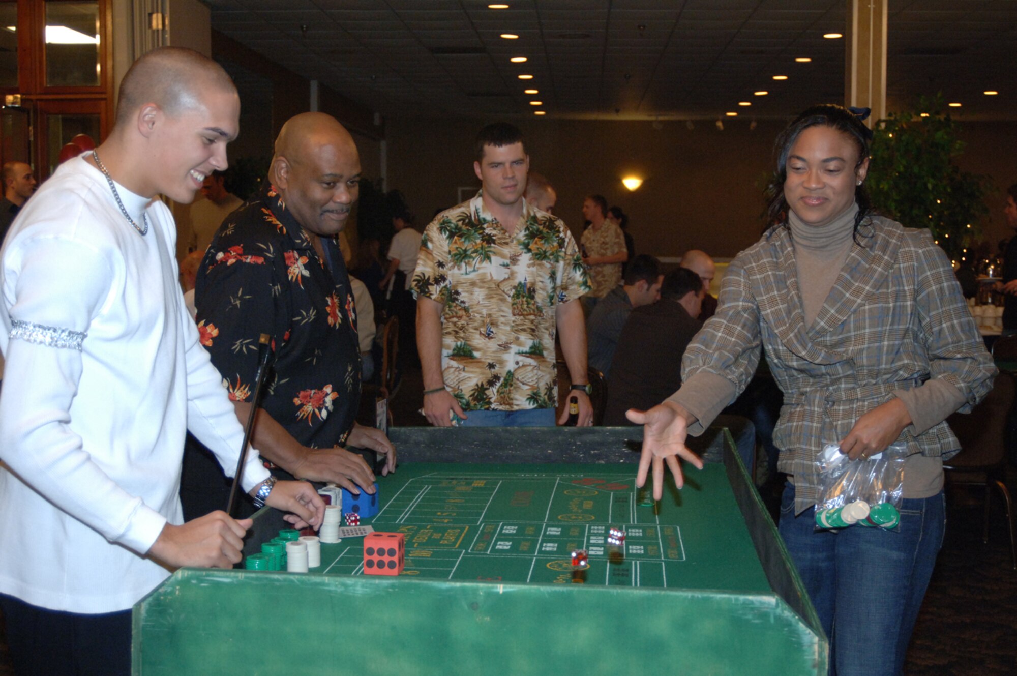 Tina Franklin, wife of Maj. Ben Franklin, 14th Medical Operations Squadron, rolls the dice at the craps table as others look on Friday at Monte Carlo Night at the Columbus Club. (U.S. Air Force photo by Airman 1st Class Danielle Hill)
