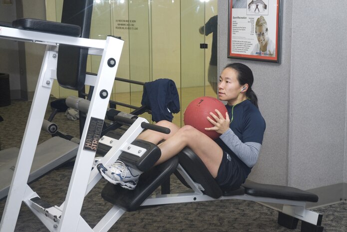 Capt. Mindy Yu, 1st Combat Camera Squadron photography flight commander,  by performing sit ups at the base Fitness and Sport Center Jan. 15. To help keep Team Charleston fit-to-fight, the center has two basketball courts, a nautilius room a free weight room and a cardio room.  The center also offers daily aerobic and indoor cycling classes through out the month. (U.S. Air Force photo by Staff Sgt. Jennifer Arredondo)