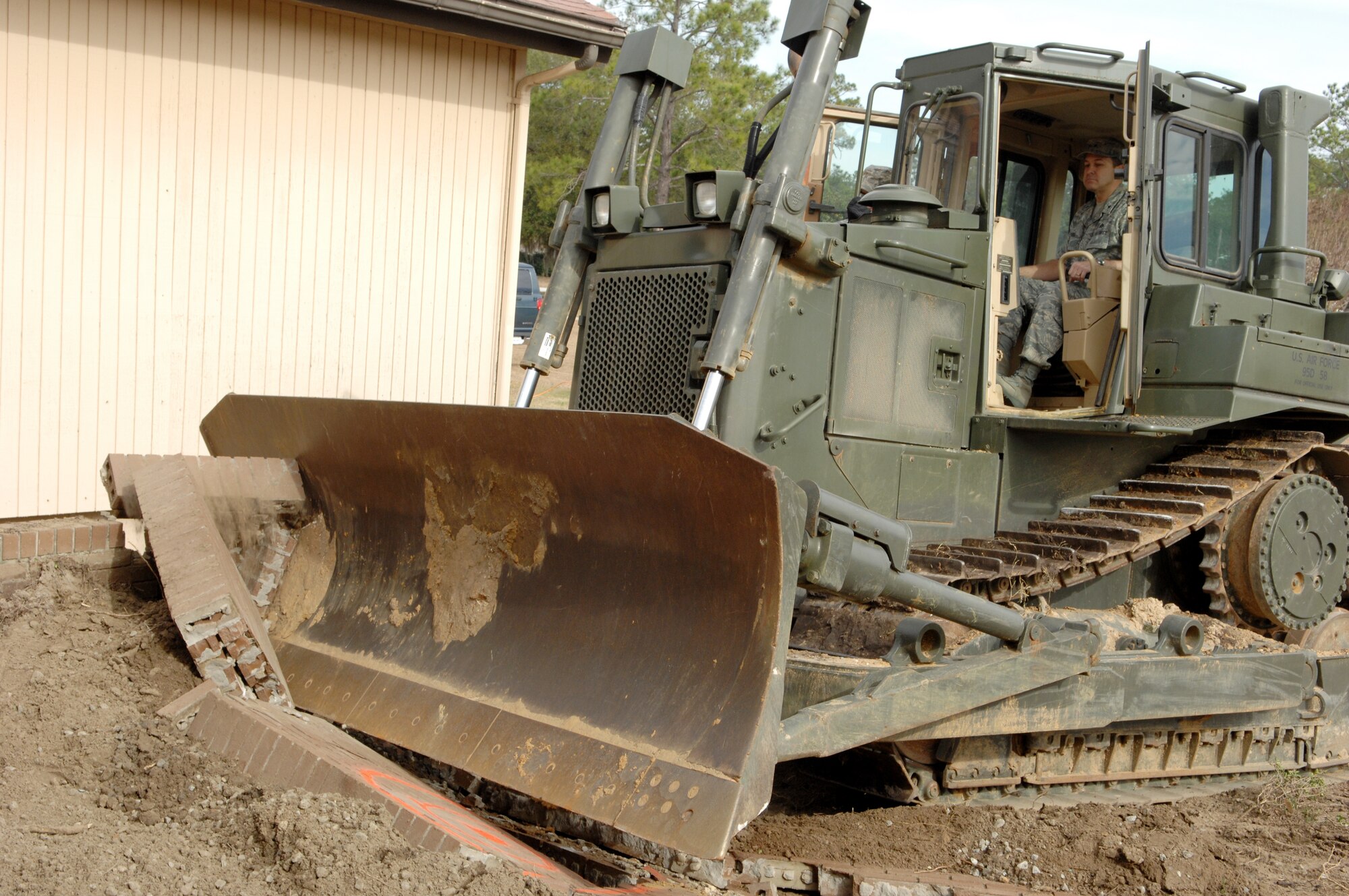 Brig. Gen. Timothy Byers, ACC/A7, drives a bulldozer into the former Moody Air Force Base legal office Jan 15.  The demolition is the first step in a $70 million base-wide construction plan. (U.S. Air Force photo by Senior Airman Angelita Lawrence)