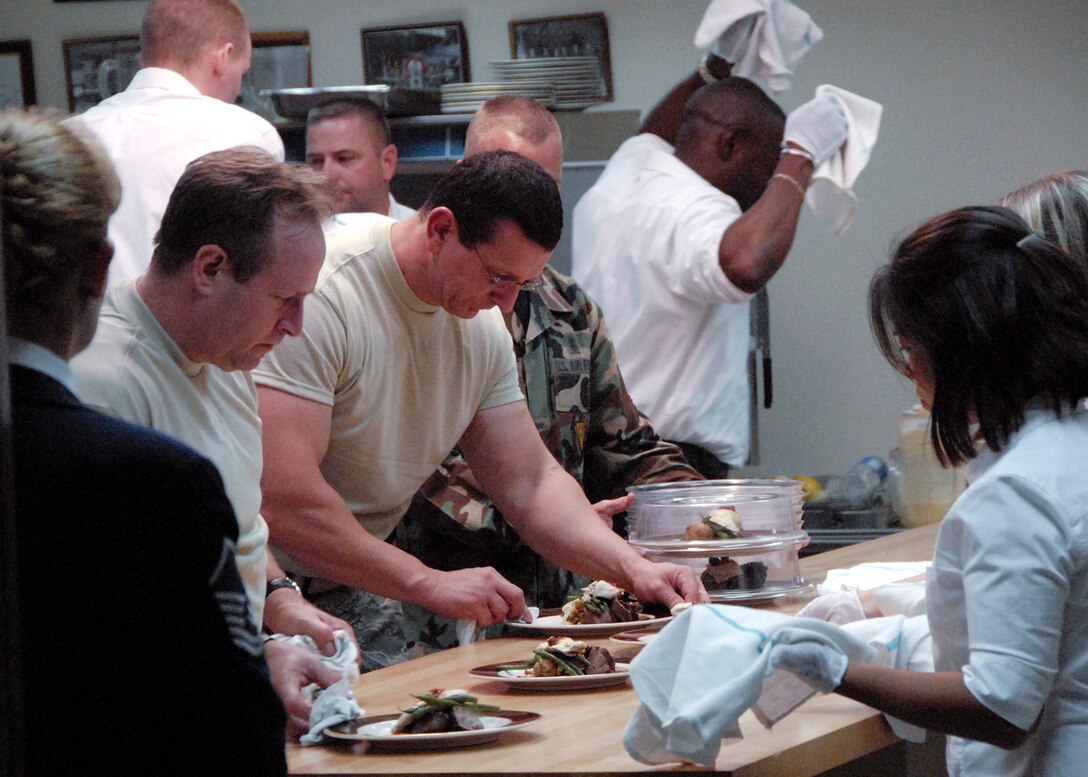 Chef Robert Irvine (center) of the Food Network's hit show "Dinner: Impossible" plates a meal the evening of Sept. 22 during Sheppard Air Force Base's celebration of the Air Force's 60th Anniversary. The chef had less than 10 hours to gather and prepare food for 1,000 Airmen and guests at the celebration. (U.S. Air Force photo/Harry Tonemah) 
