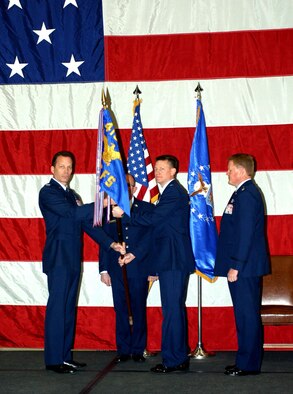 Col. Andrew Larsen, 419th Operations Group commander, passes the 466th Fighter Squadron flag to Lt. Col. Pat Wade at a change of command ceremony during the January UTA, as Lt. Col. Paul Madsen, the former 466th FS commander looks on.  Colonel Wade had served as commander of the wing’s Operations Support Flight commander for nearly two years and has been a pilot with the 466th FS for more than five years. (U.S. Air Force photo /SSgt. Kyle Brasier)