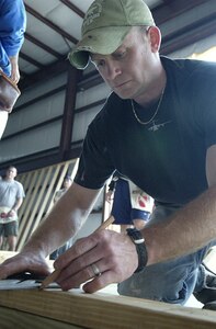 Tech. Sgt. Michael Cowart, 300th Airlift Sqaudron, preps a board to be cut at the new site for the Habitiat for Humanity Restore in Jedburg, S.C., Jan. 11.  Because of the additional funds generated by the restore, more individuals will be taken out of substandard living and given the opportunity to purchase a brand new home, said Ms. Epps. (U.S. Air Force photo by Staff Sgt. Jennifer Arredondo)                               