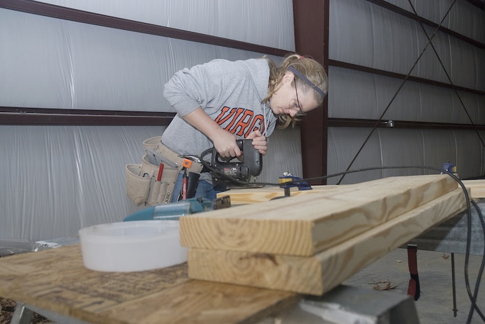 Allison Powell, volunteer for Habitiat for Humanity, who works for Amercores Construction, helps in the buidling process by preparing pieces of wood to be used in the construction of the new Restore in Jedburg S.C. Jan. 11.  Items to be sold will include donated furnishings, appliances and other household items. (U.S. Air Force photo by Staff Sgt. Jennifer Arredondo)