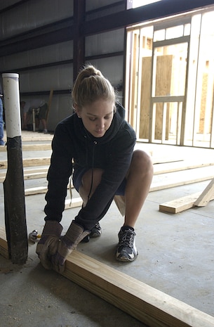 Airman 1st Class Crystal Davis, 437th Medical Group, lines up boards to be used in a wall frame in the Habitat for Humanity Retore in Jedburg S.C., Jan. 11.  The profit from the restore helps in the building of one to two houses every years (U.S. Air Force photo by Staff Sgt. Jennifer Arredondo)                                