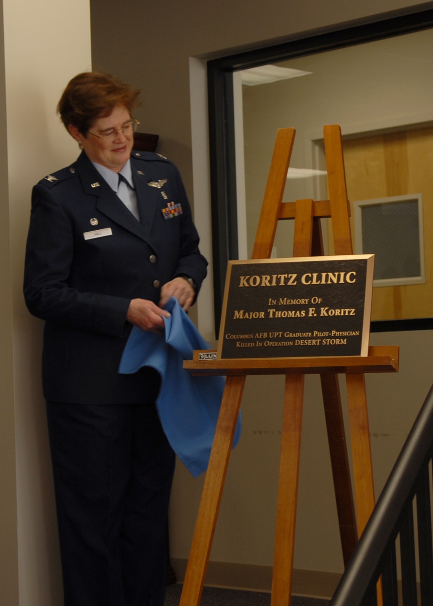 Colonel Susan Hall, 14th Medical Group commander, unveils the sign reveiling the new name of the clinic Friday. The clinic was named after Major Thomas Kortiz, a former Air Force pilot-physician.  Major Koritz was a 1981 Specialized Undergraduate Pilot Training Distinguished Graduate. (U.S. Air Force photo)
