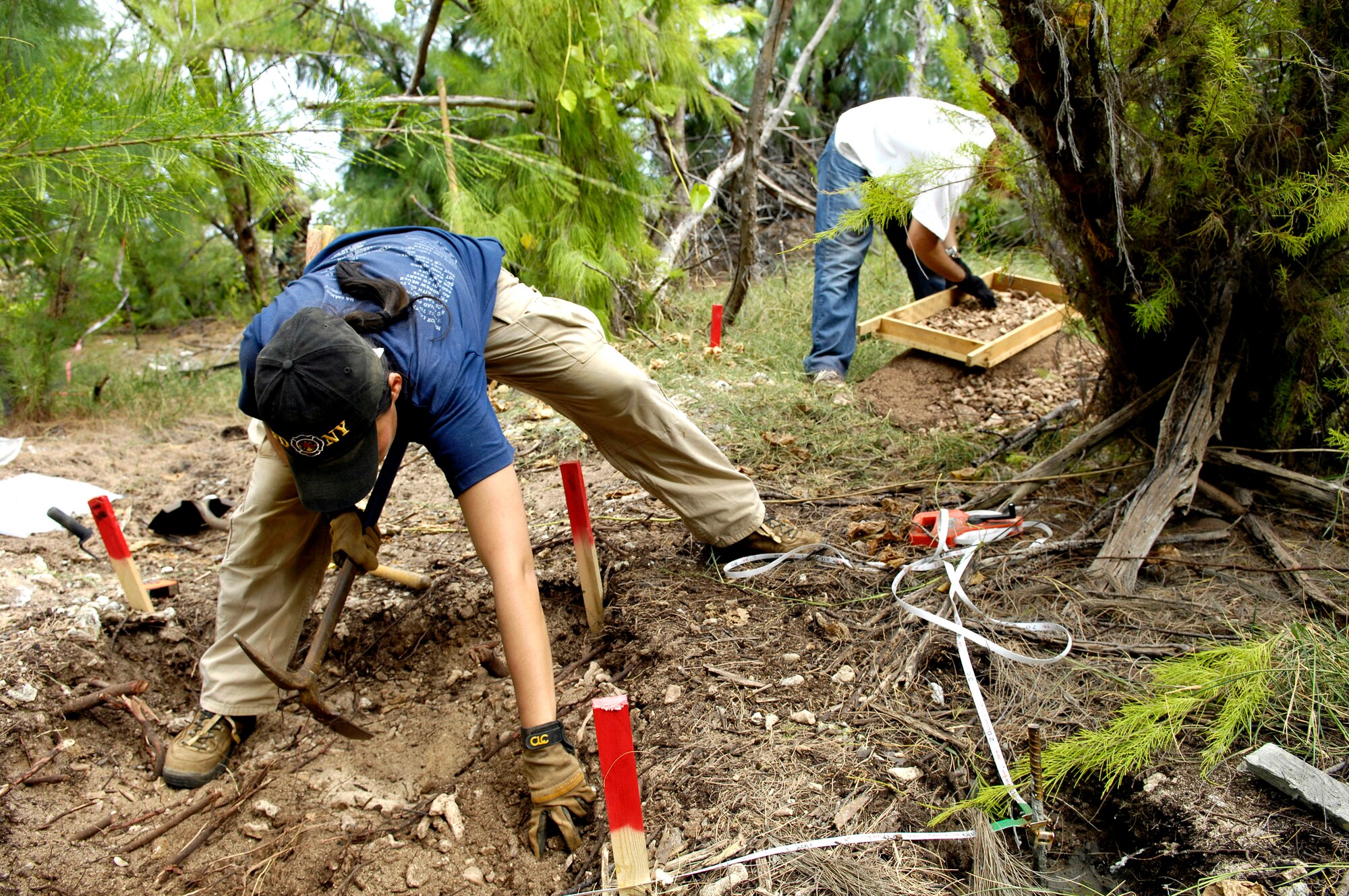 Denise To and Greg Berg excavate a dig site Jan. 12 on Wake Island. Ms. To and Mr. Berg, forensic anthropologists, were sent to do a site survey after Wake Island officials notified the Joint POW/MIA Accounting Command of bones located on the island. JPAC officials are charged with achieving the fullest possible accounting of all Americans missing as a result of past conflicts. (U.S. Air Force photo/Tech. Sgt. Shane A. Cuomo)