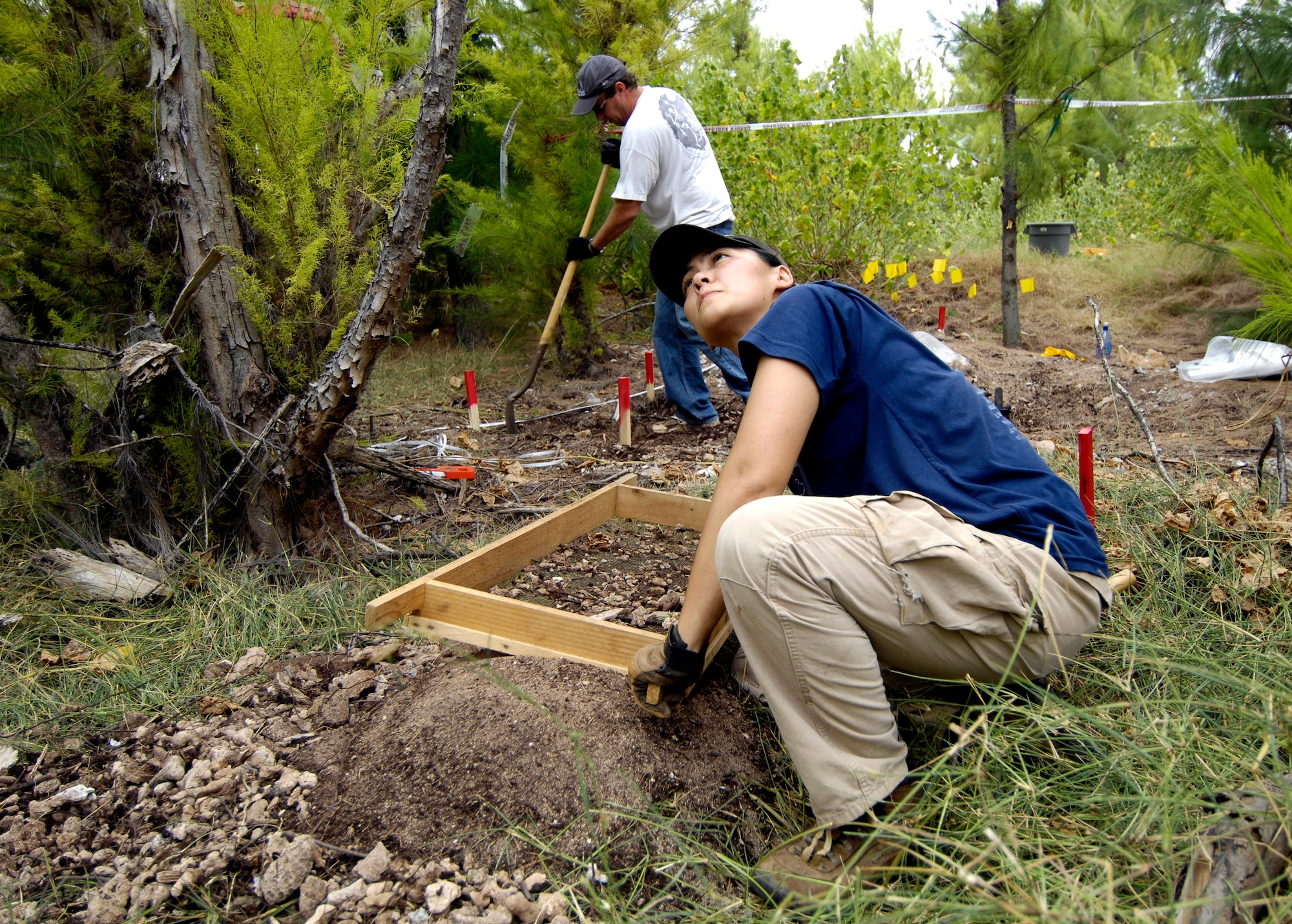 Denise To and Greg Berg excavate a dig site Jan. 12 on Wake Island. Ms. To and Mr. Berg, forensic anthropologists, were sent to do a site survey after Wake Island officials notified The Joint POW/MIA Accounting Command of bones located on the island. JPAC is charged with achieving the fullest possible accounting of all Americans missing as a result of past conflicts. (U.S. Air Force photo/Tech. Sgt. Shane A. Cuomo)
