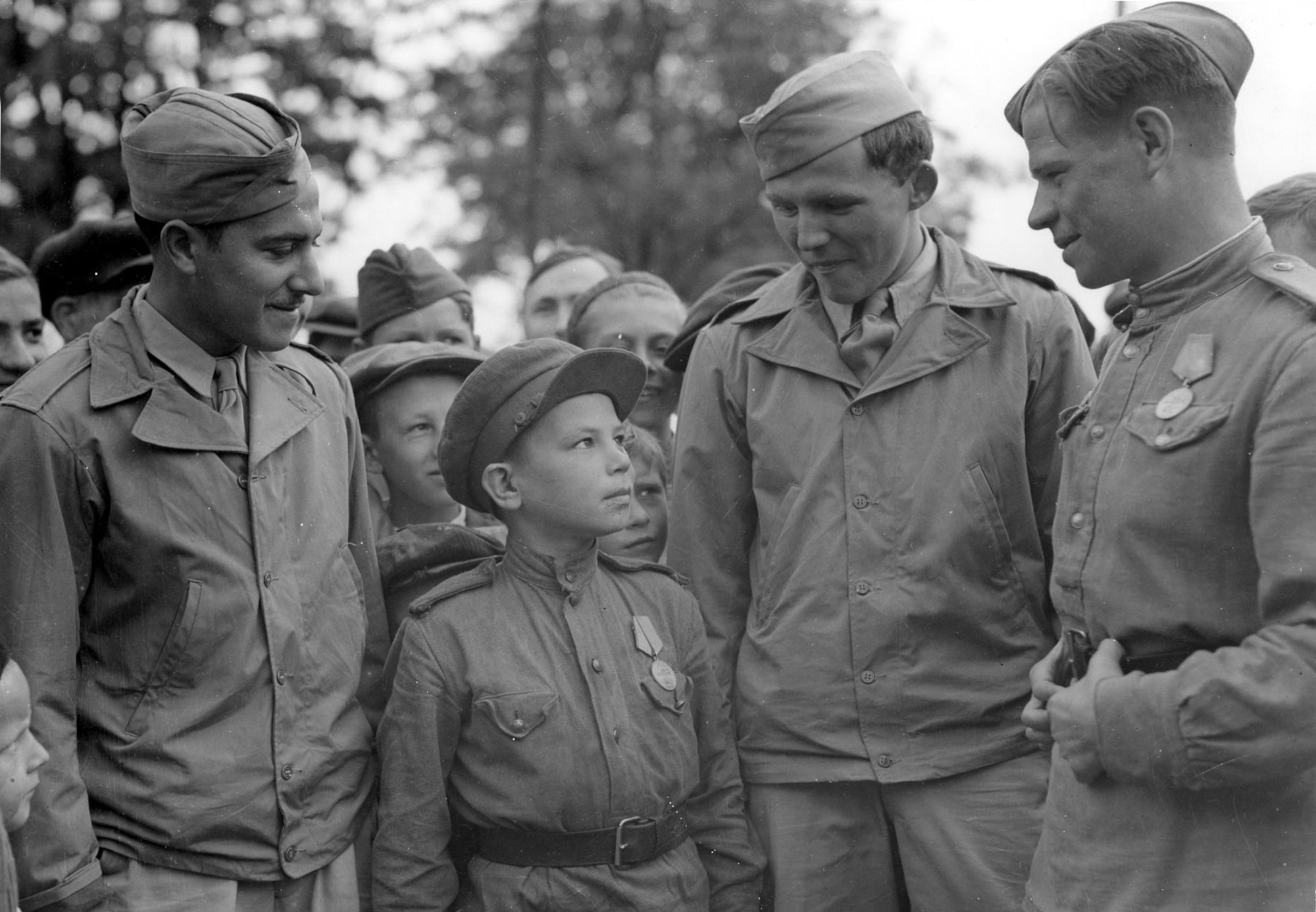 Sgt. S. Weinschenker and TSgt. William Topps talk to a 10-year-old boy who had been in uniform as an A/A loader for three years. (U.S. Air Force photo)