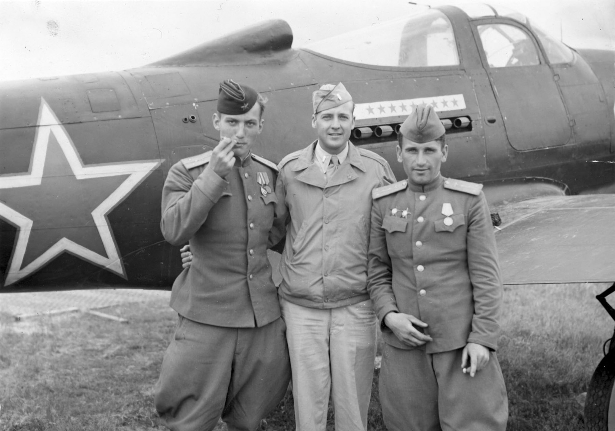 Andrea Hincerockur, a Russian pilot; Lt. Thompson Highfill of the 99th Bomb Ground; and Corzen Venzopkin, another Russia flier, pose behind a Soviet P-39. (U.S. Air Force photo)