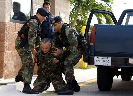 Staff Sgt. Agustin Blanco (left), Tech. Sgt. Edgar Valpais (right) and Department of Defense Officer Darrell Thiel (background) apprehend Tech. Sgt. Jose Maldonado (middle), who acted as an assailant during a 482nd Security Forces Squadron exercise testing front gate defense on Jan. 15. The Defenders were presented with multiple scenarios involving reacting to an attack, apprehending an armed assailant, responding to casualties, establishing on-scene commander and alerting response forces. The exercise was videotaped, and members critiqued themselves afterwards to further learn from the scenarios. (U.S. Air Force photo/Senior Airman Erik Hofmeyer)