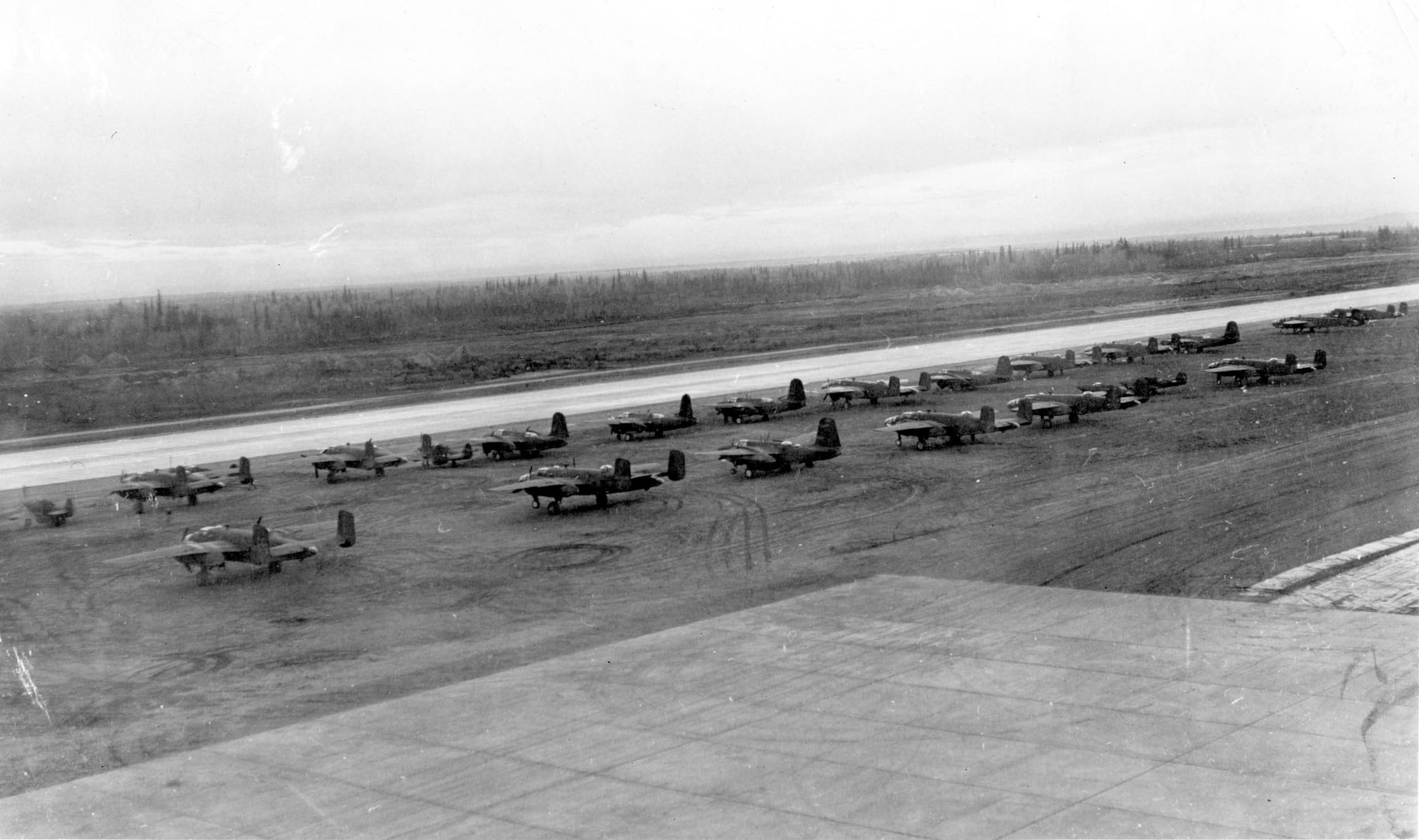 Lend-lease B-25s and P-39s on the runway at Ladd Field, Alaska, prior to testing by the Soviet Purchasing Commission, September 1942. (U.S. Air Force photo)