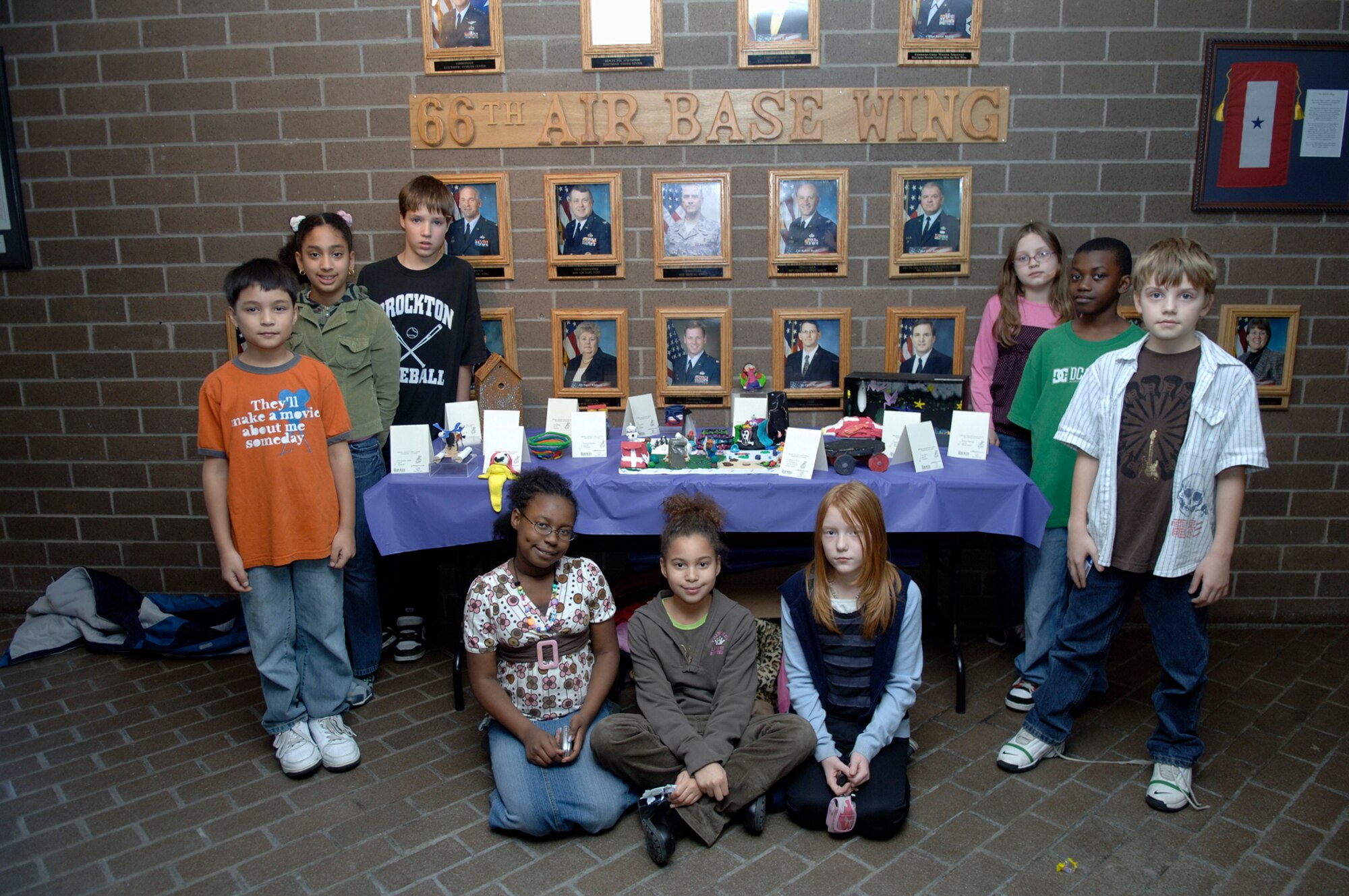 HANSCOM AFB, Mass. – Members of the Hanscom Youth Center recently participated in the Boys & Girls Club National Fine Arts Program. The youth were on hand to talk about their masterpieces on Jan. 11 when the exhibit went on display in the lobby of the Brown Building. Pictured here on the left (front to back) Christopher Sjolie, Julianne Sandoval and Troy Briggs. On the right are Benjamin Irwin, Aric McCoy and Emily Dixon.  In the front row (left to right) are Jocelyn Dickey, Malayah Montgomery and Vally Purtle. The exhibit will be displayed at the Minuteman Club from Jan. 16 to Jan. 23. (U.S. Air Force photo by Jan Abate)