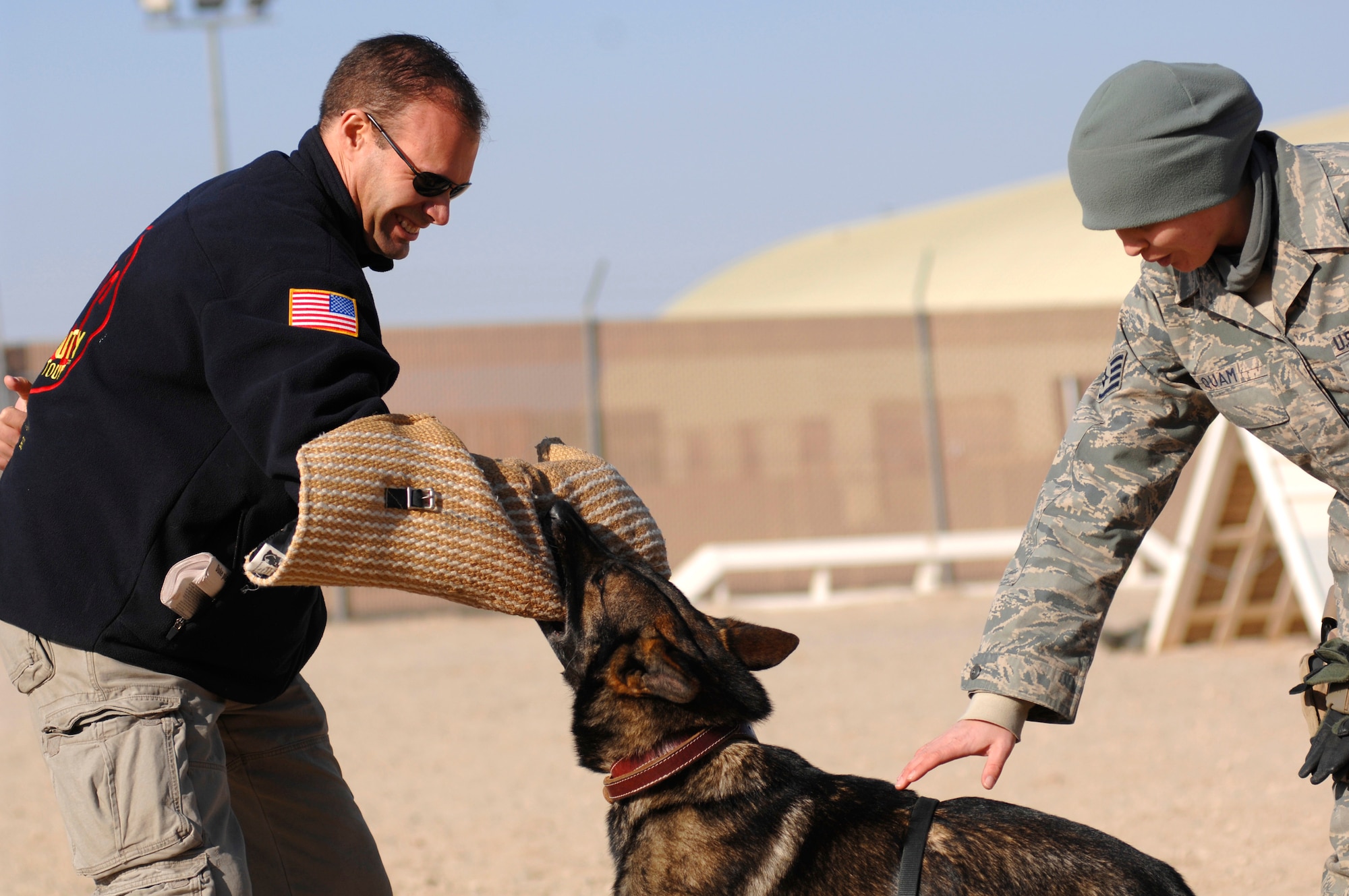 Keith Alberstadt, a comedian on the Comics on Duty World Tour, is attacked by Ori, a military working dog while partner and K-9 handler Staff Sgt. Christa Quam, 386th Expeditionary Security Forces Squadron stands nearby during the Jan. 15, 2007, K-9 demonstration. Mr. Alberstadt is one of four American entertainers who visited the air base in the Persian Gulf Region. (U.S. Air Force photo/Senior Airman Patrick Dixon) (Released)