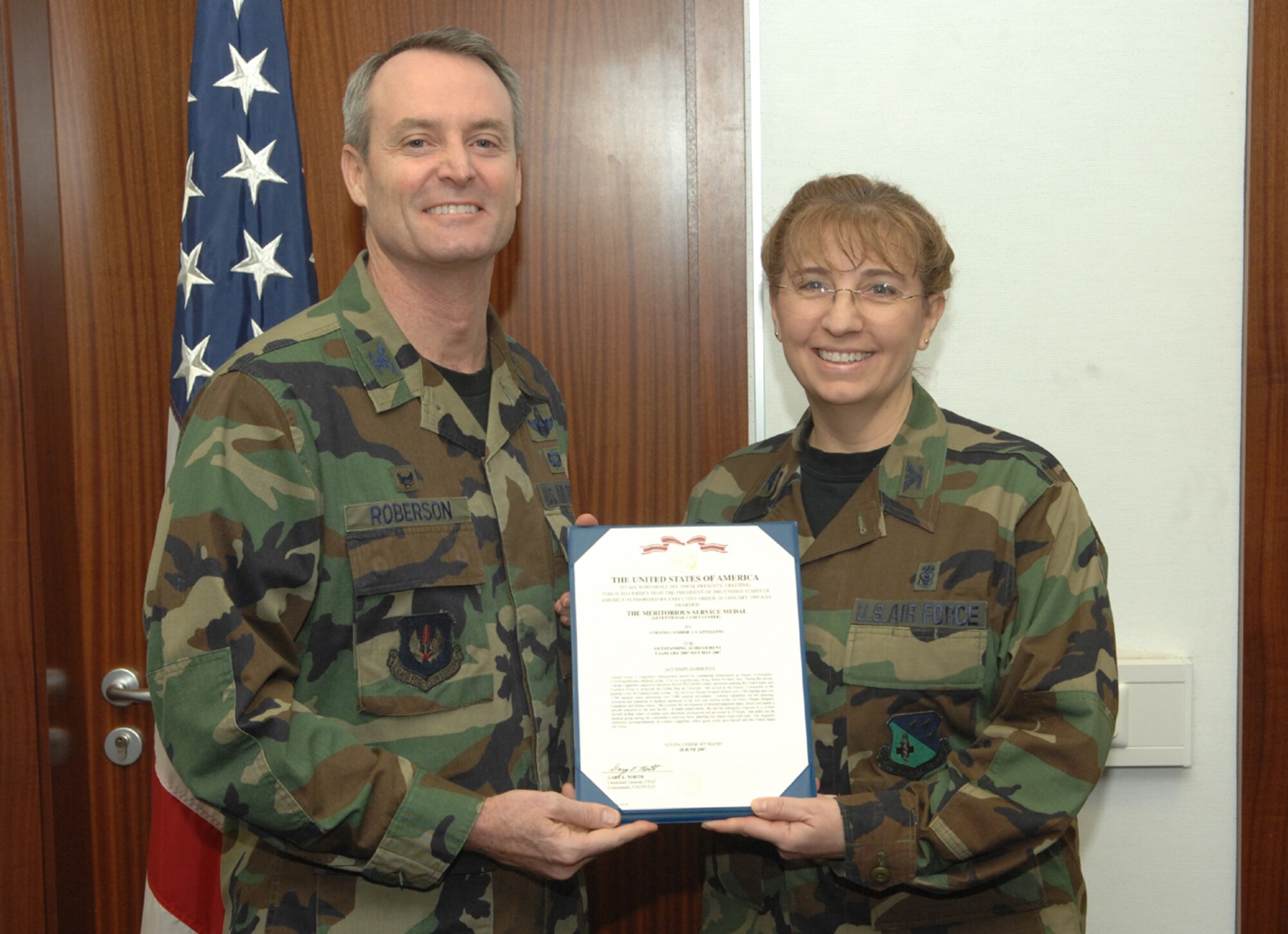 SPANGDAHLEM AIR BASE, Germany -- Col. Darryl Roberson, 52nd Fighter Wing commander, presents Col. Lorrie Cappellino, 52nd Medical Group commander, a Meritorious Service Medal Jan. 16, 2008. Colonel Cappellio was recognized for work at the Air Force Theater Hospital while deployed to Balad Air Base, Iraq. (U.S. Air Force photo/Senior Airman Matt Bright)