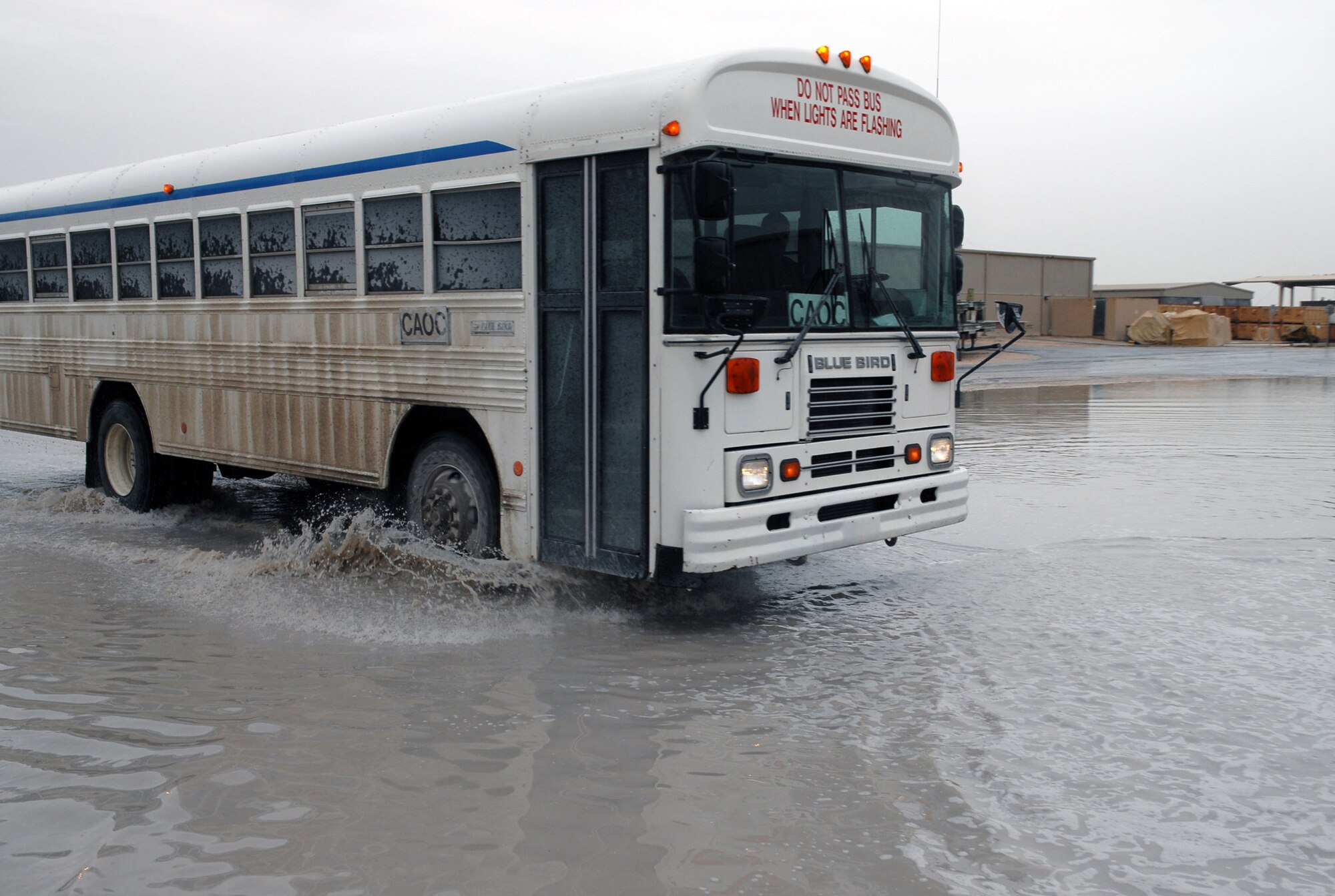 SOUTHWEST ASIA-- A shuttle bus drives through a vast puddle of water created by recent precipitation at a Southwest Asia air base Jan. 15. The base is entering the rainy season and downpours of rain in the past few days have left some areas of roadway flooded and other areas with pools of standing water. (U. S. Air Force photo/Senior Airman Domonique Simmons)