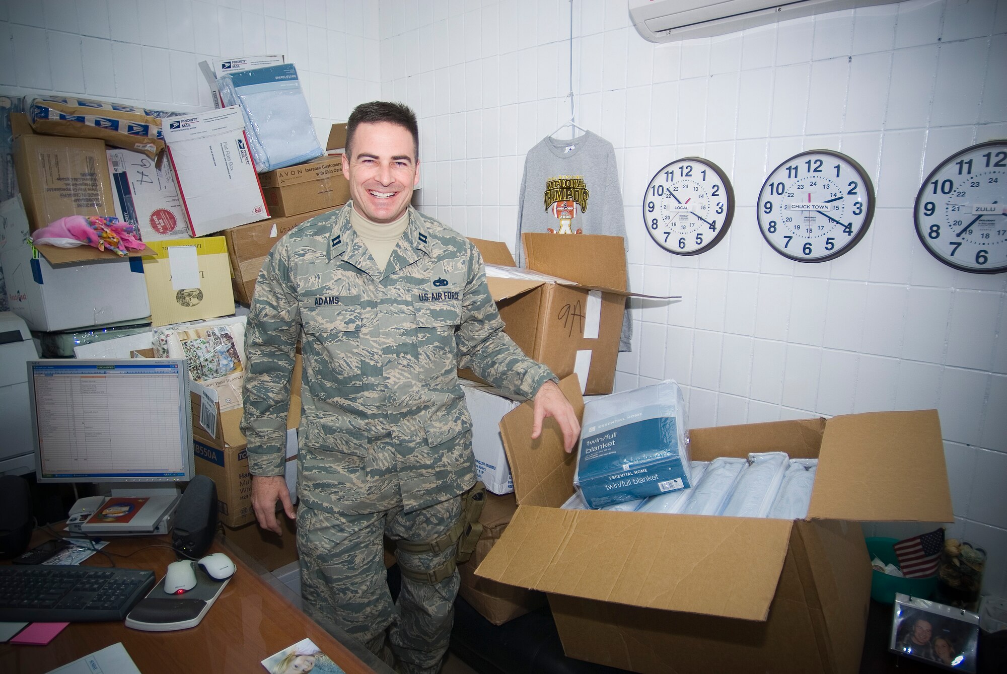 BALAD AIR BASE, Iraq -- Capt. Taylor Adams, 721st Aircraft Mobility Operations Group, Detachment 5 commander, stands alongside blankets donated by friends and family for patients at the Air Force Theater Hospital here, Jan. 16. Captain Adams, who volunteers at the Contingency Aeromedical Staging Facility, shared a story with his wife about an injured Iraqi child that led members of their community to send blankets to support Iraqi and American patients. Captain Adams is a member of the Air Force Reserve deployed from Charleston Air Force Base, S.C. (U.S. Air Force Photo/Master Sgt. John R. Nimmo, Sr.)