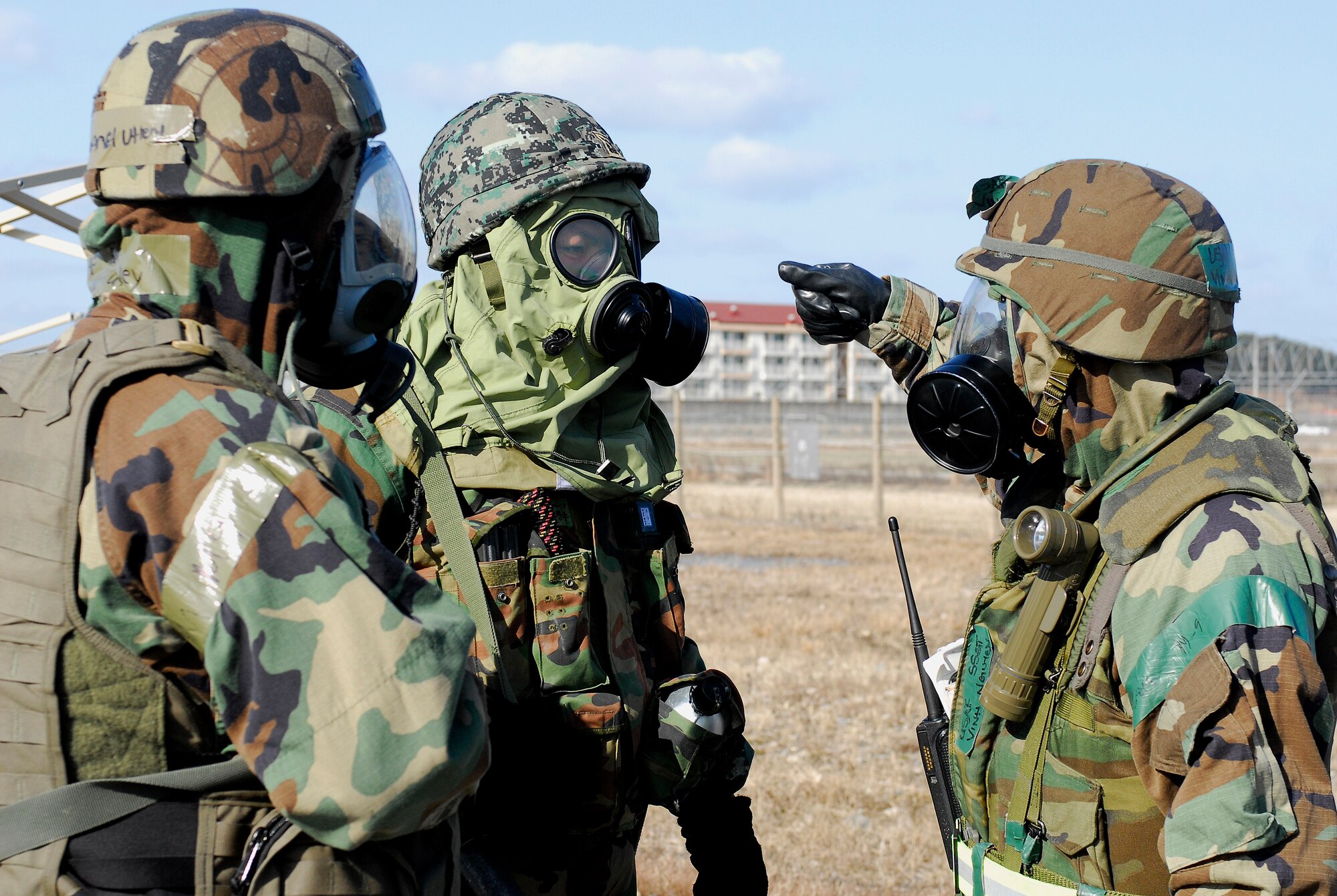 KUNSAN AIR BASE, South Korea -- Staff Sgt. Vinh Nguyen, 8th Comptroller Squadron, tells Staff Sgt. Channel Utley, 8th Security Forces Squadron, and a Korean soldier the procedures to remove contaminated gear during a peninsula wide operations readiness exercise. Republic of Korea Army soldiers and 8th Security Forces Squadron members demonstrate the teamwork necessary to carry out the combined mission of the two allies stationed at Kunsan during a PENORE. (U.S. Air Force photo/Senior Airman Giang Nguyen)