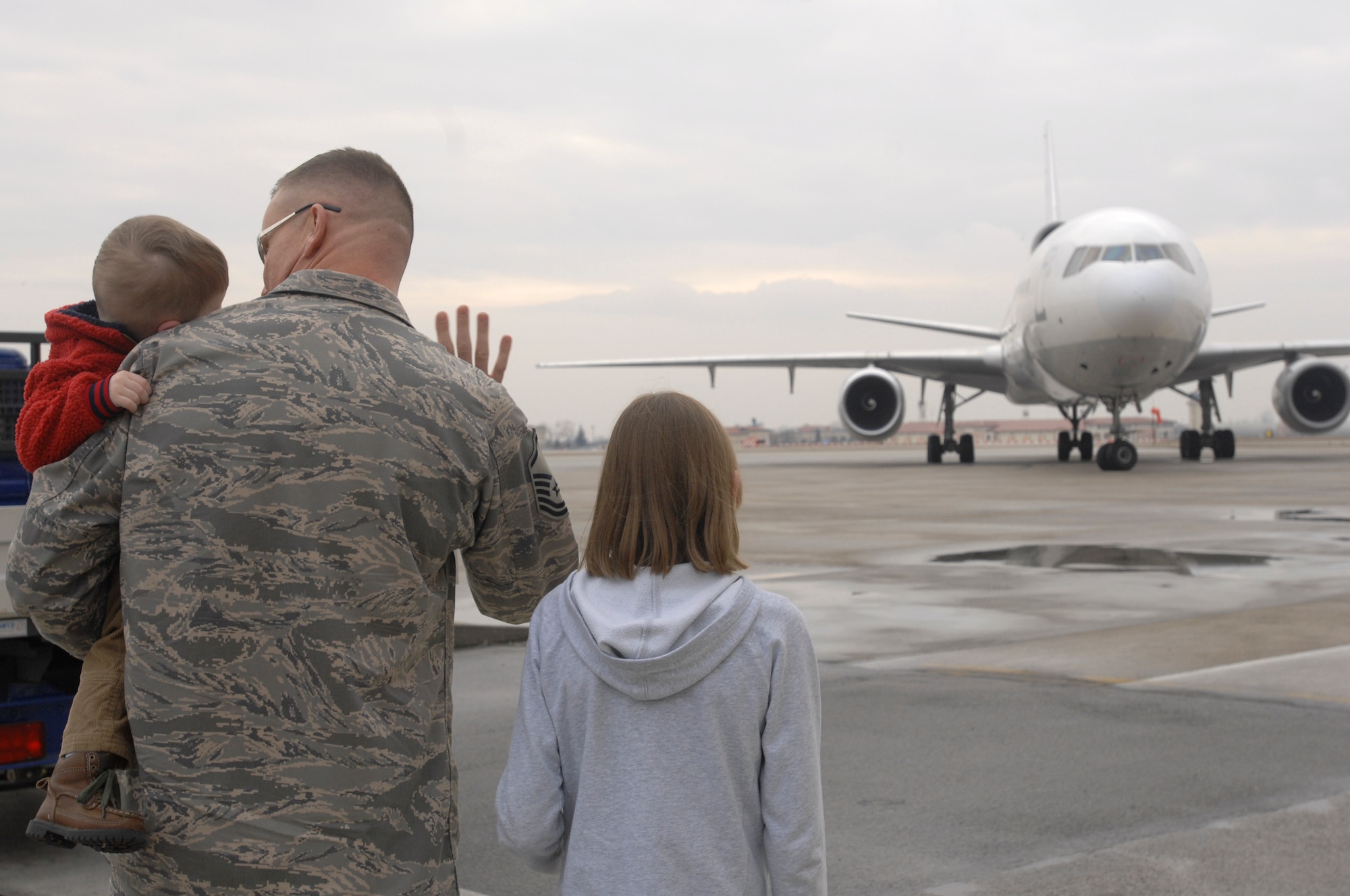 AVIANO AIR BASE, Italy-- Master Sgt. Chris Crafton and his two children, Zackary Crafton and Taylor Crafton, wait anxiously for their wife and mother, Master Sgt. Paige Crafton, to exit the air craft from a four month deployment Jan.15, 2008 at Aviano Air Base, Italy.  (U.S. Air Force photo / Airman 1st Class Ashley Wood)