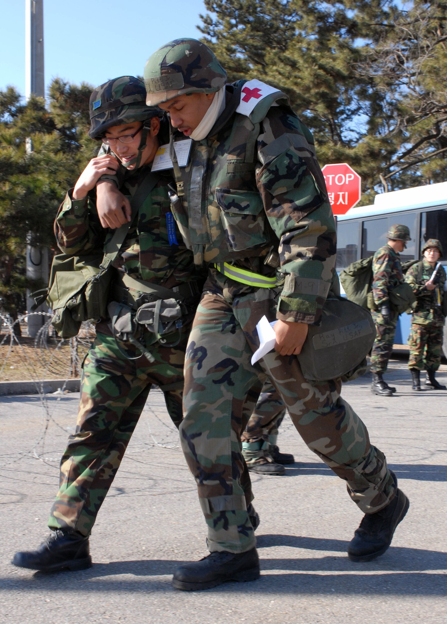 KUNSAN AIR BASE, South Korea -- A Republic of Korea Air Force medic escorts Senior Airman Ray Pitt Jr., 8th Medical Group, after a mass causality scenario during the peninsula wide operations readiness exercise as the exercise evaluation team observes here Jan. 16. This is the first training scenario between the ROKAF and 8th Medical Group and demonstrates the teamwork necessary to carry out the combined mission of the two allies stationed at Kunsan. (U.S. Air Force photo/Senior Airmen Steven R. Doty)