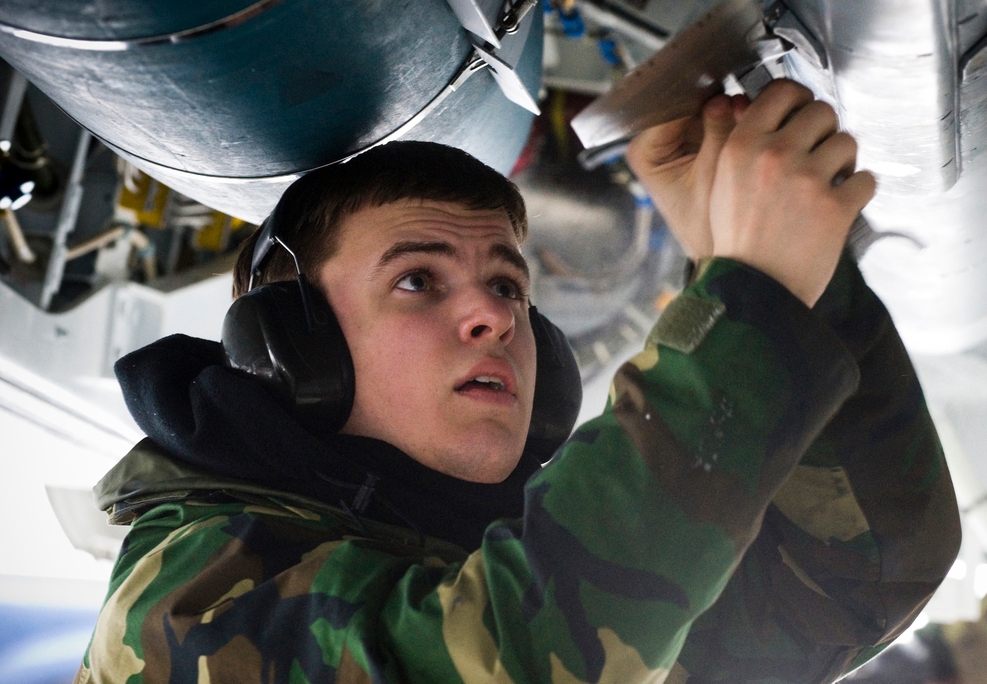 ELMENDORF AIR FORCE BASE, Alaska - Airman 1st Class Jacob Dean, 3rd Aircraft Maintenance Squadron, 90th Aircraft Maintenance Unit, attaches fins to munitions loaded in the F-22A Raptor bomb bays Jan. 16. For the first time at Elmendorf, a mock bomb drop over Alaska provided integral training for both fighters and maintainers in preparation to declare the unit's initial operation capabilities. (U.S. Air Force photo/Senior Airman Garrett Hothan)