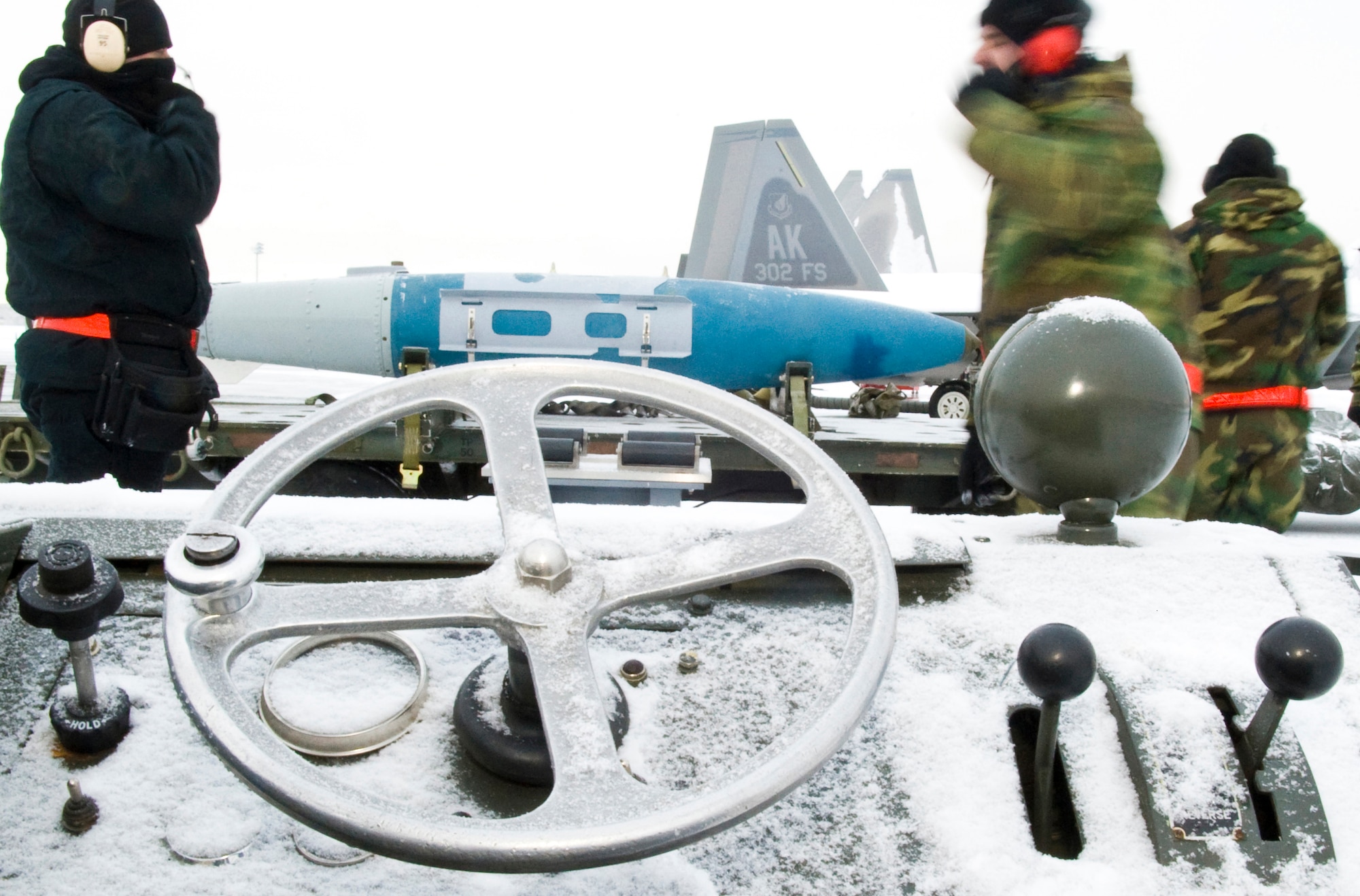 ELMENDORF AIR FORCE BASE, Alaska - Heavy equipment, bombs and aircraft are covered with snow and frost as members of the 3rd Aircraft Maintenance Squadron, 90th Aircraft Maintenance Unit systematically piece together the tools necessary to complete the F-22A Raptor payload. For the first time at Elmendorf, a mock bomb drop over Alaska Jan. 16 provides integral training for both fighters and maintainers in preparation to declare its initial operation capabilities. (U.S. Air Force photo/Senior Airman Garrett Hothan)