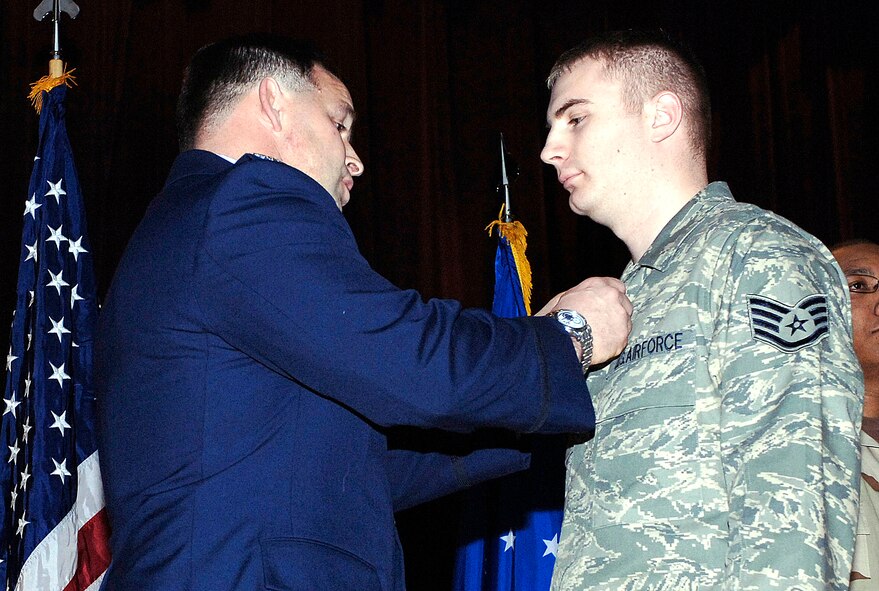 FAIRCHILD AIR FORCE BASE, Wash. –– Col. Thomas Sharpy, 92nd Air Refueling Wing commander, presents Staff  Sgt. Jeremy Walker, 92nd Logistics Readiness Squadron, the Purple Heart on Jan. 15 at the base theater. (U.S. Air Force photo/Staff Sgt. JT May III)