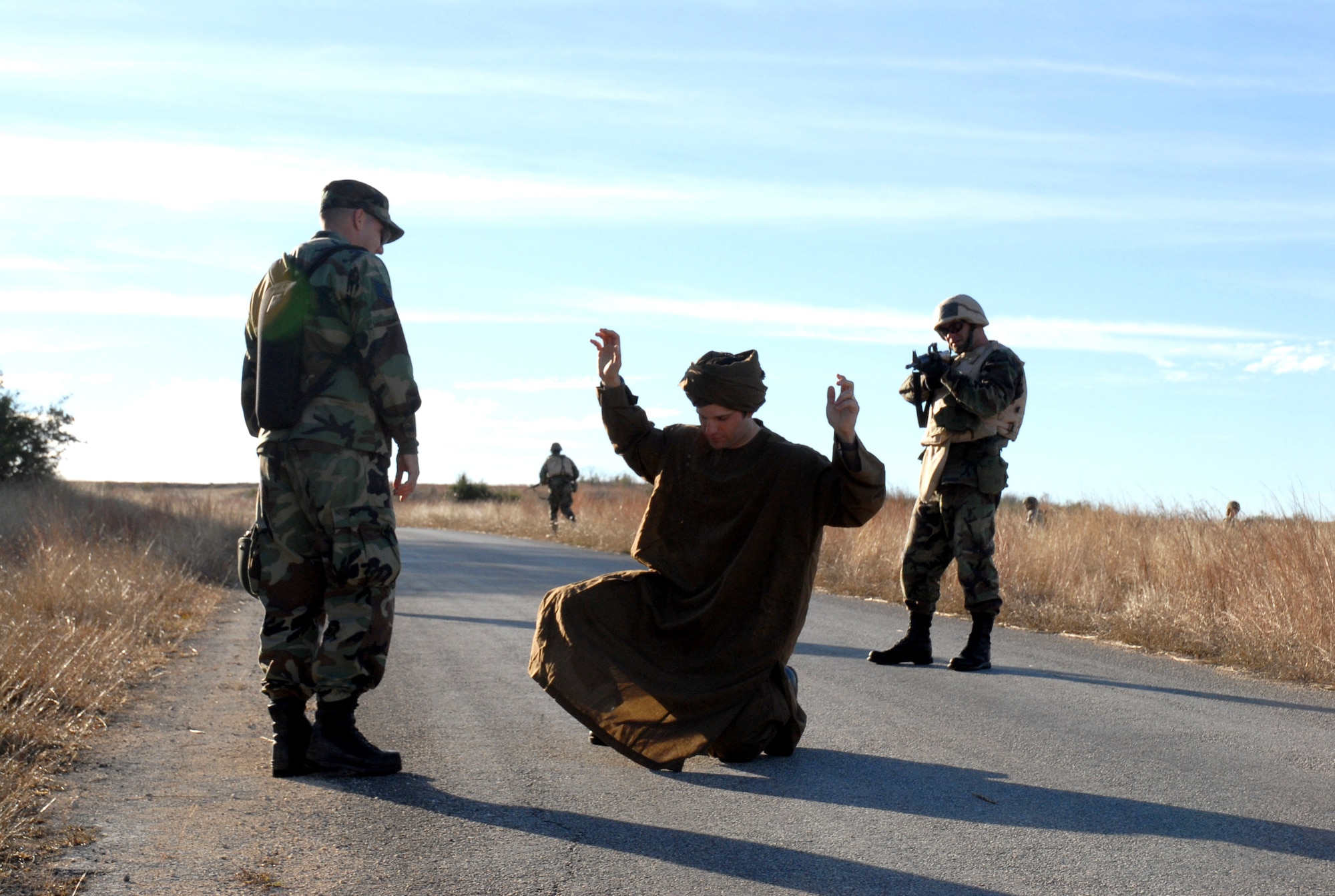 Maj. Roy Thrailkill (right) simulates challenging an insurgent Jan. 10 during the new Common Battlefield Airman Training Bridge course held at Camp Bullis, Texas. Instructor Tech. Sgt. Christopher Dunstone acts as an interpreter. CBAT-B course instructor Staff Sgt. Joe Pearcy acts as the insurgent. CBAT-B course cadre consist of Airmen of all specialties, including security forces, transportation, explosive ordnance disposal, survival, combat weather, tactical air control, combat control and pararescue. Major Thrailkill is a member of the Air Education and Training Command at Randolph Air Force Base, Texas. (U.S. Air Force photo/Staff Sgt. Beth Del Vecchio) 