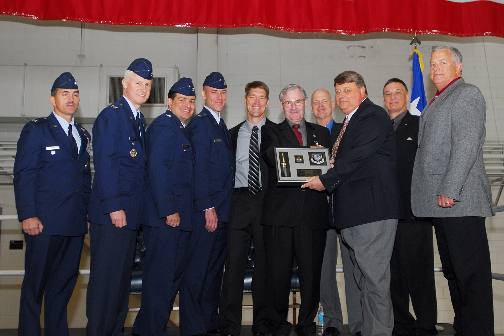 Mr. Klingaman, (fifth from right) was presented a dagger plaque by all of the former 6th SOS commanders. (Left to right) Col. Jim Sikes, Col. Norm Brozenick, Col. John Alvarez, Lt. Col. Dave Tabor, current 6th SOS commander, retired Lt. Col. Eric Huppert, retired Col. Scott Pugmire, retired Maj. H. Scott Murphy, who is not a former 6th SOS commander but the holder of 6th SOS Coin #1, retired Lt. Col. Monty Sexton and retired Col. Steve Whitson. (Courtesy photo)