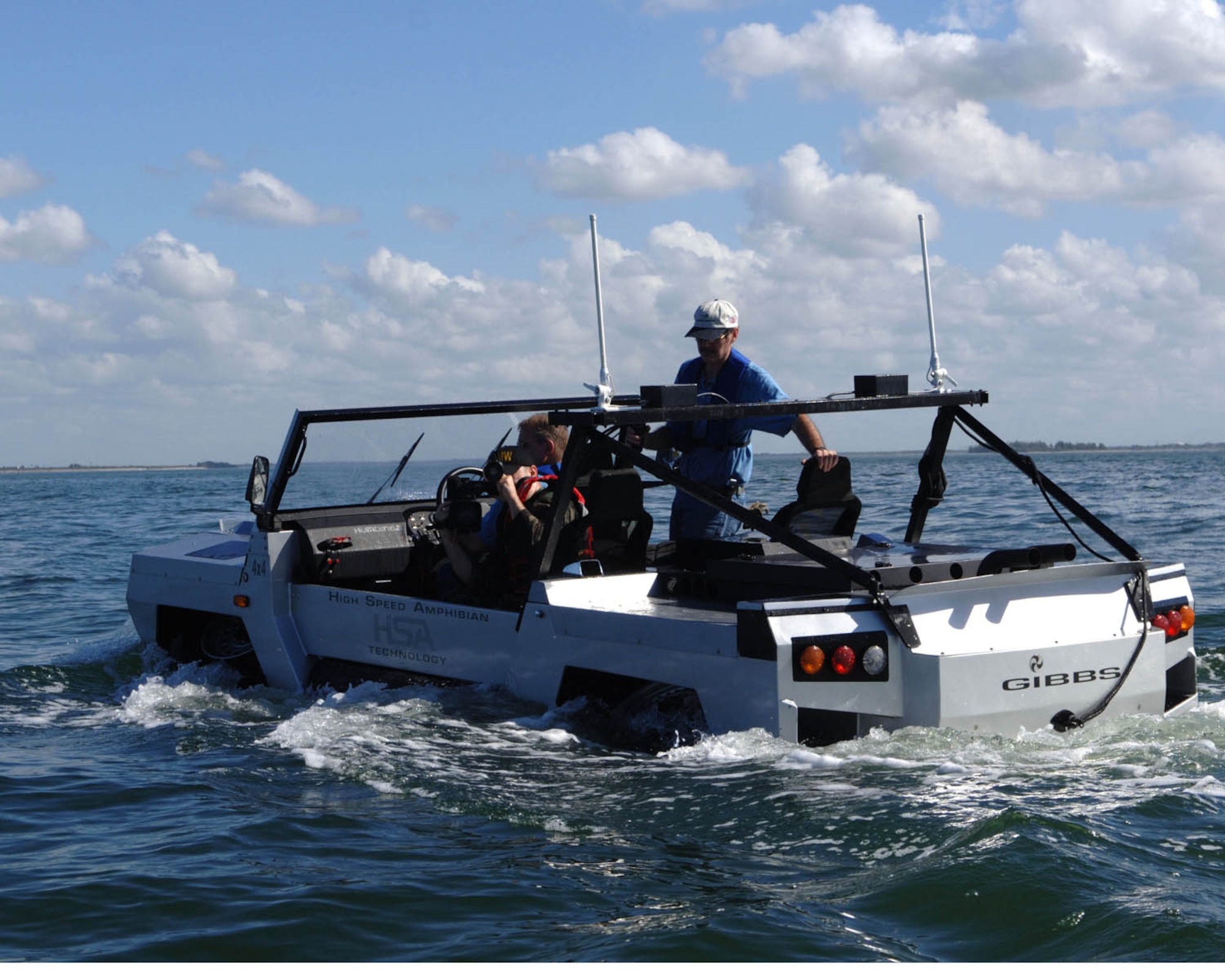 Lockheed Martins Steve Schlatter looks on as US Air Force SrA Esteban Rodriguez videos while taking a ride on the Lockheed Martin/GIBBS high speed amphibian vehicle called the Humdinga driven by Mark Chrzanowski at the Marina on Macdill AFB, Florida, Jan 10, 2008.  The Humdinga is capable of reaching speeds of 80 miles per an hour on land and 40 miles per an hour on the water.

 (U.S. Air Force photo by Staff Sergeant Joseph Swafford, Jr.)(Released)